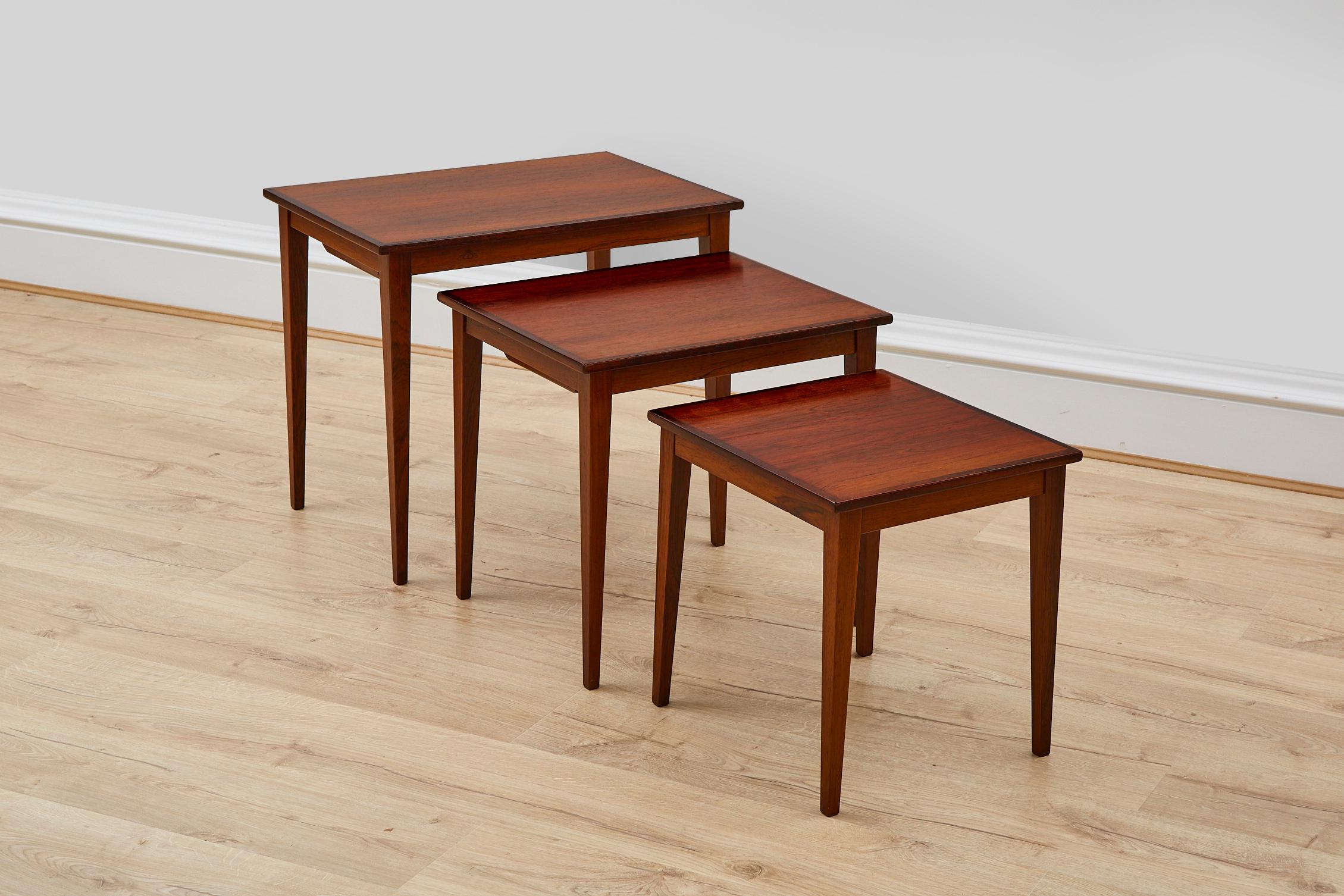 This is a set of 3 rosewood nesting tables from 1960s Demark. The tables have rosewood top and solid rosewood legs and edges. The table tops have been repolished. All 3 tables are in very good vintage condition.