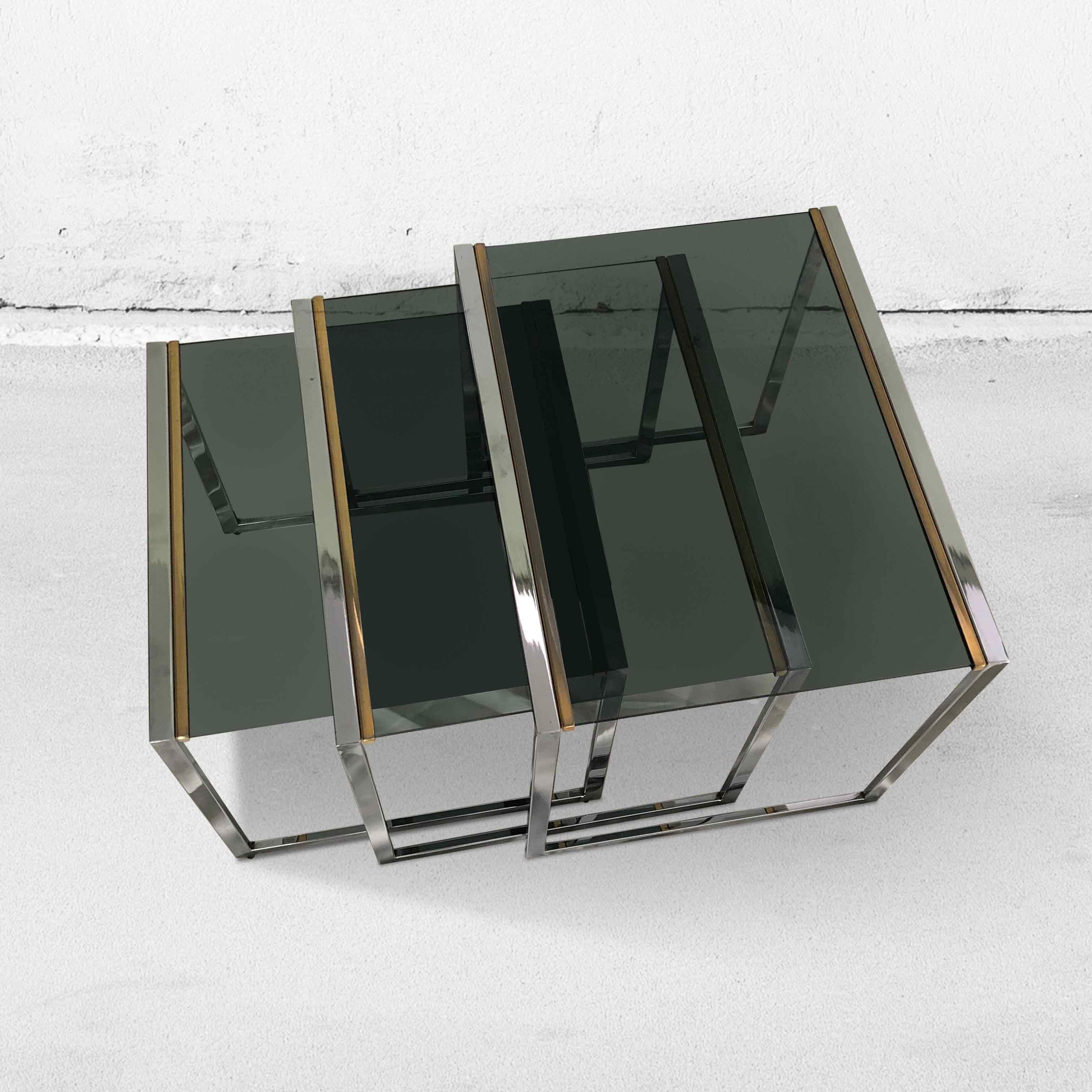 Vintage set of 3 nesting tables in chrome (silver/gold) and smoked glass. Because the tables can be pushed together, they take up little space. And due to the minimalist style, they fit into almost any interior.

 Belgium,
