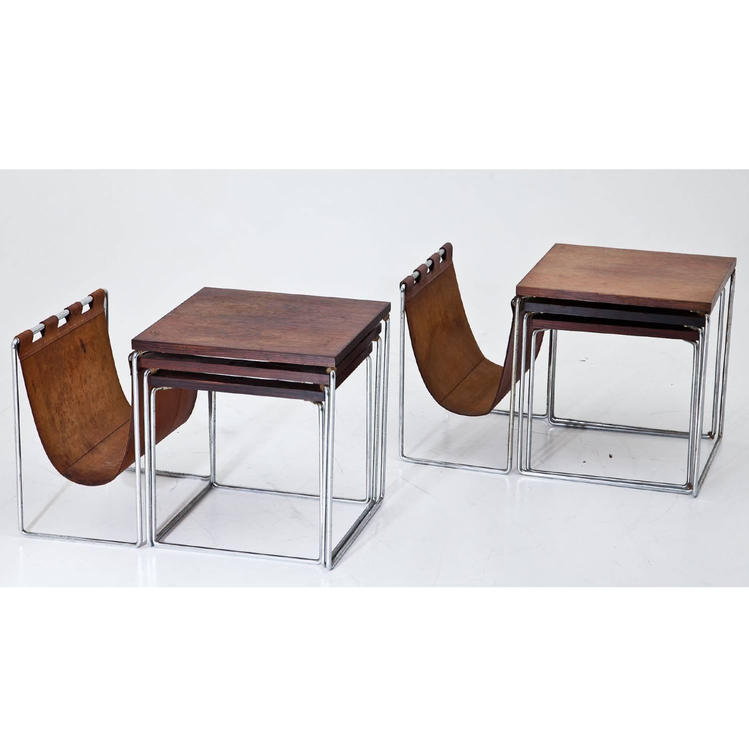 Pair of nesting tables with two smaller tables each and a magazine rack out of brown leather. Each table has a square table top and stands on bent steel feet. The smaller tables have the following 
measurements (H x W x D):
33 x 32 x 32 cm & 31 x