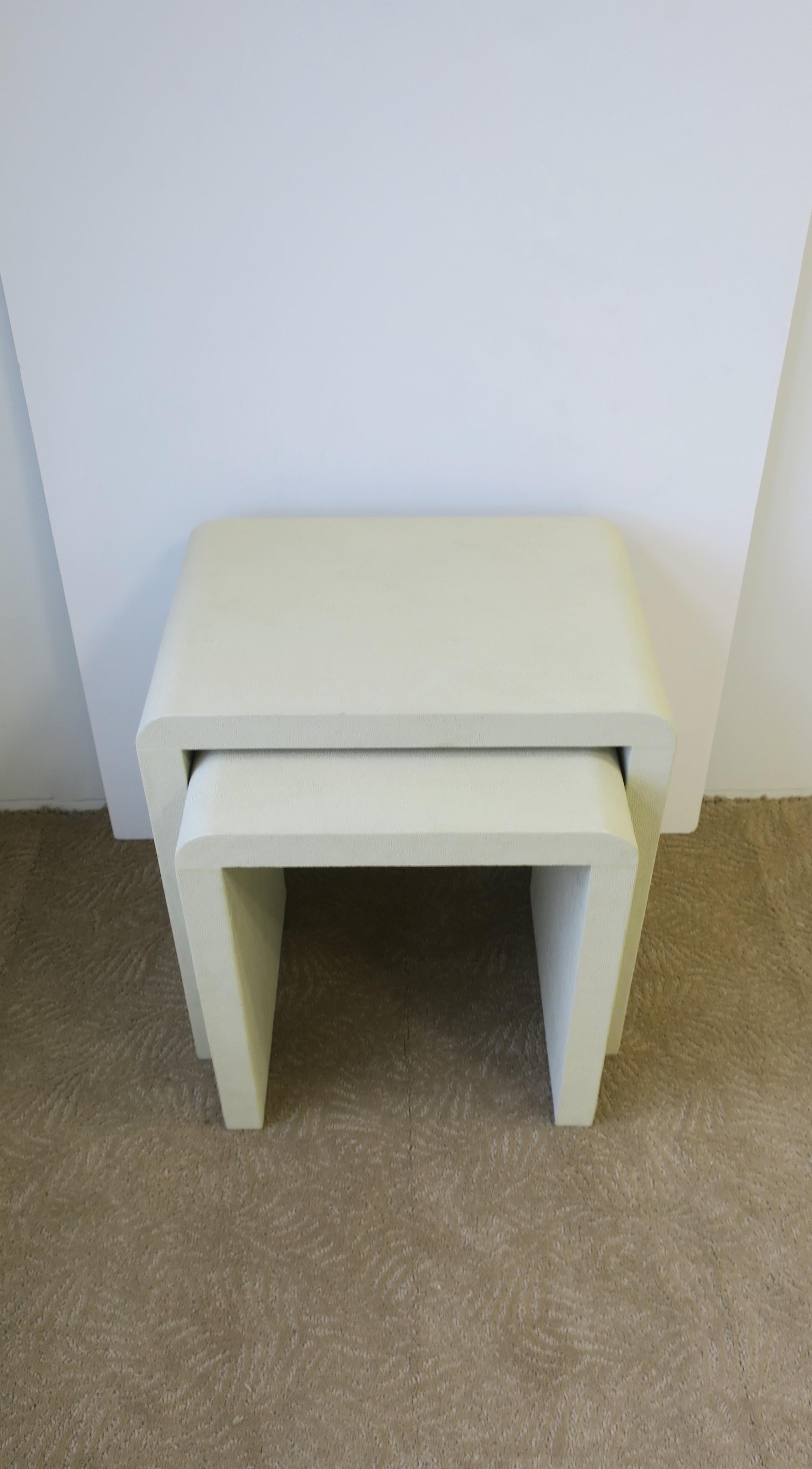 A set of modern style nesting or end tables with 'waterfall' edge in a neutral/taupe hue and a shagreen-esque (faux) veneer. 

Tables measure: 
Top: 19.5