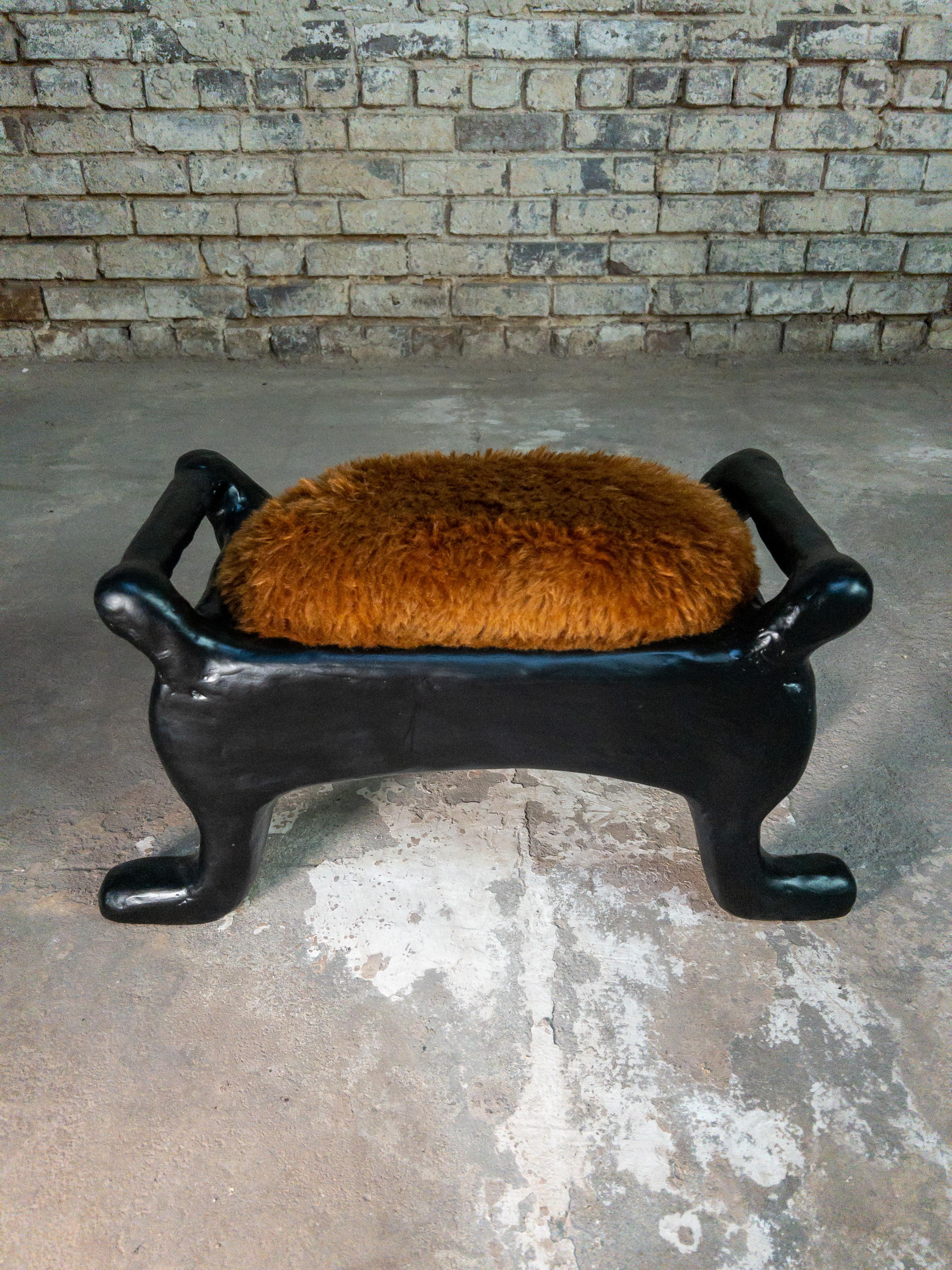The Nestle Foot Stool by Brent Warr is a tactile blend of whimsy and sculptural sophistication. Its exaggerated legs and rounded silhouette are crafted from a wood core and shaped using a proprietary mix of gypsum, pulp, and epoxy. A sleek black