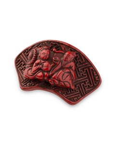 Nestuke in red lacquer carved in theform of a fan using the tsuishu technique