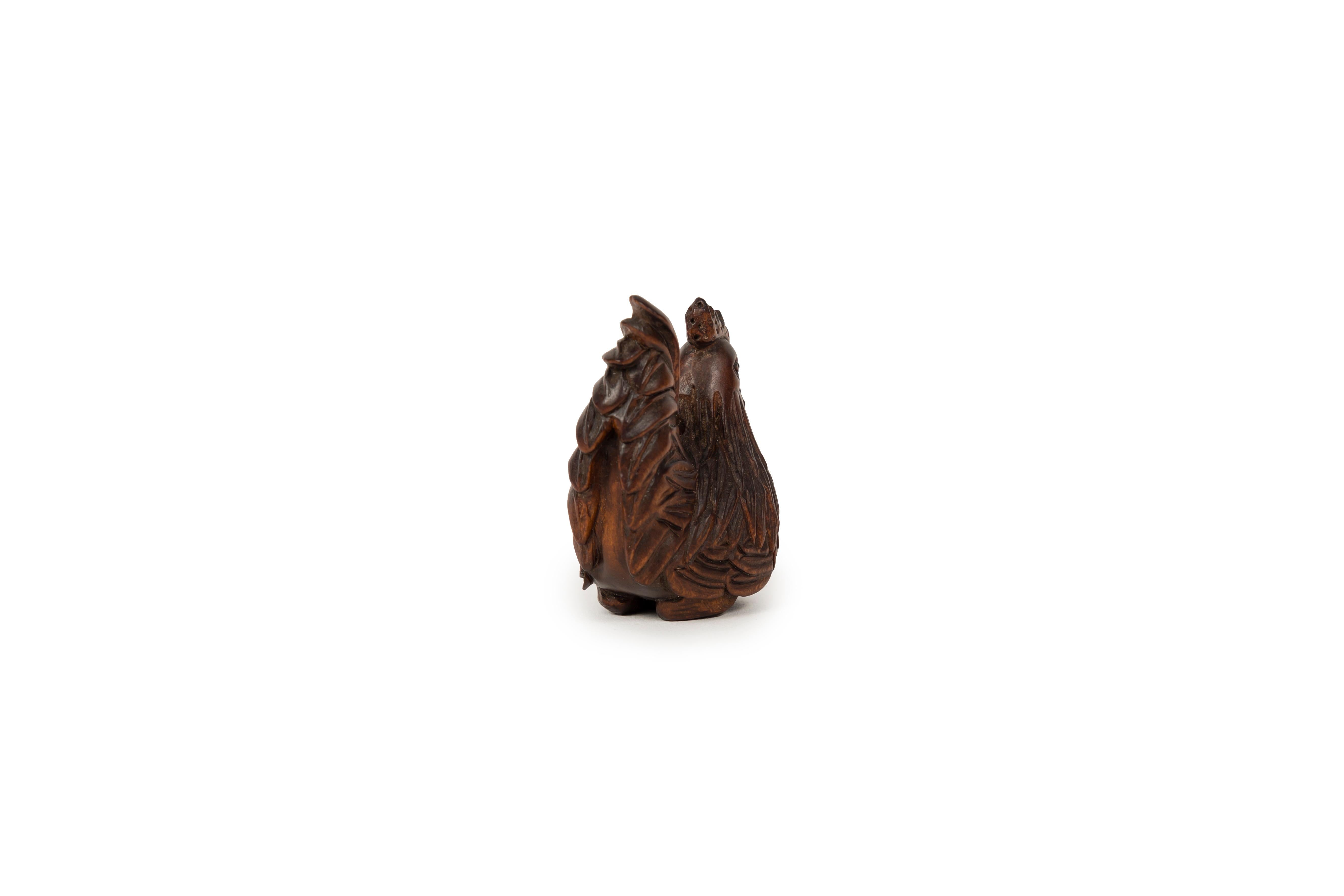 Small yet interesting netsuke in boxwood representing a seated rooster. The finish of its dishevelled feathers is neat, while the details of comb and the beak are treated with great realism. Verny nice brown patinq of use, characteristics of netsuke