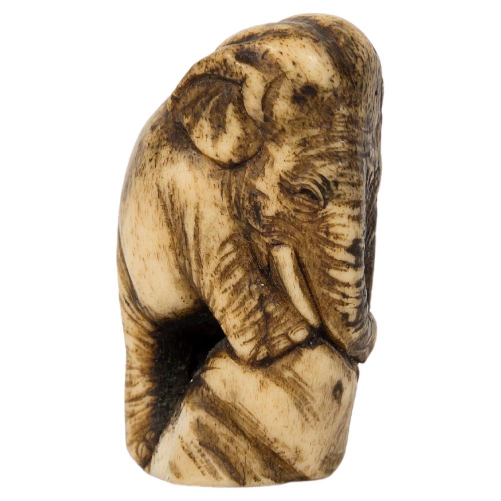 Netsuke in deer antler in the form of an elephant standing on some rock For Sale