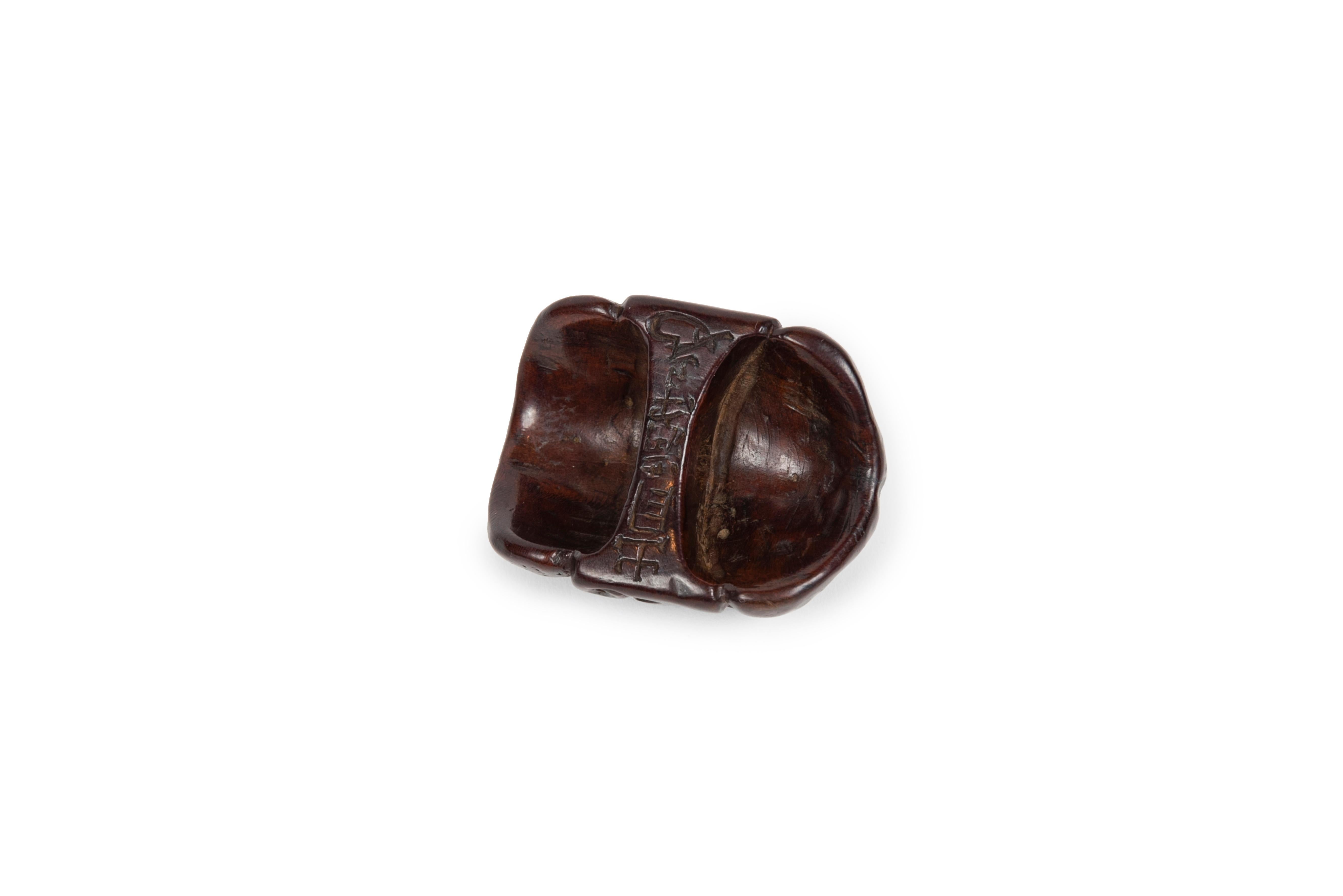 Wooden netsuke depicting the Obeshimi mask in Noh theater.
Obeshimi is a demon characterized by thick eyebrows, eyes that seem to protrude from the face and a closed mouth. 

Signed on the back: 