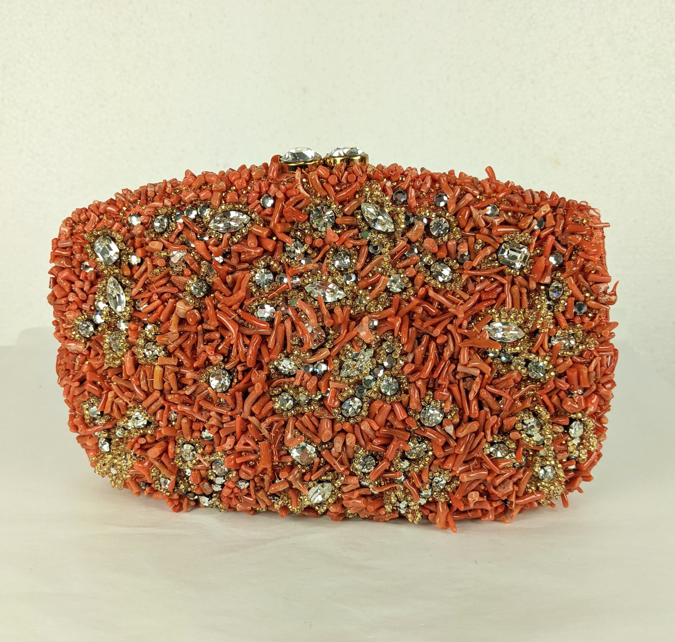 Rare, collectible Nettie Rosenstein Coral and Pave Crystal Clutch from the 1960's. Genuine branch coral is used with crystal rose montees and accented with citrine crystal glass bead decoration. Completely hand embroidered on coral silk tussah base.