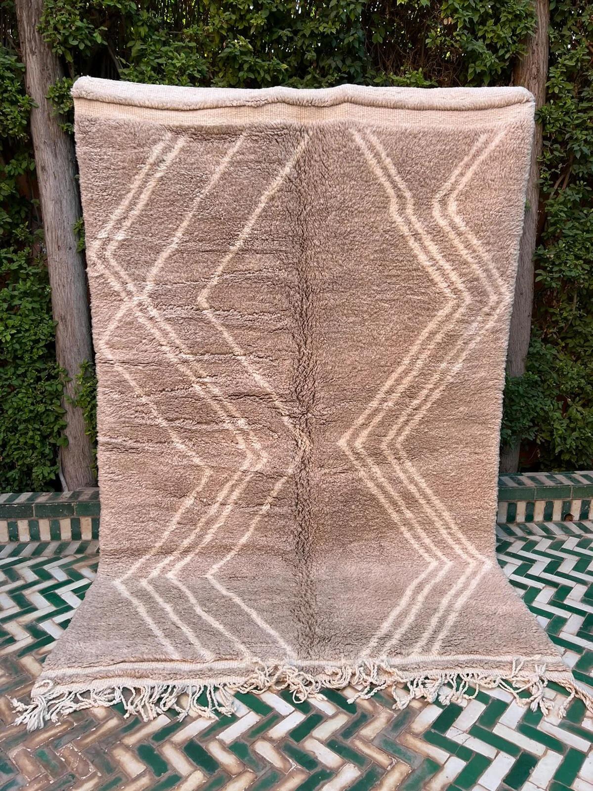 Cet élégant tapis marocain moderne tissé à la main a été fabriqué à la main par des tisserands qualifiés dans les montagnes de l'Atlas au Maroc. Ce tapis marocain classique et neutre est tissé avec de la laine M'rirt ultra douce et de haute qualité.