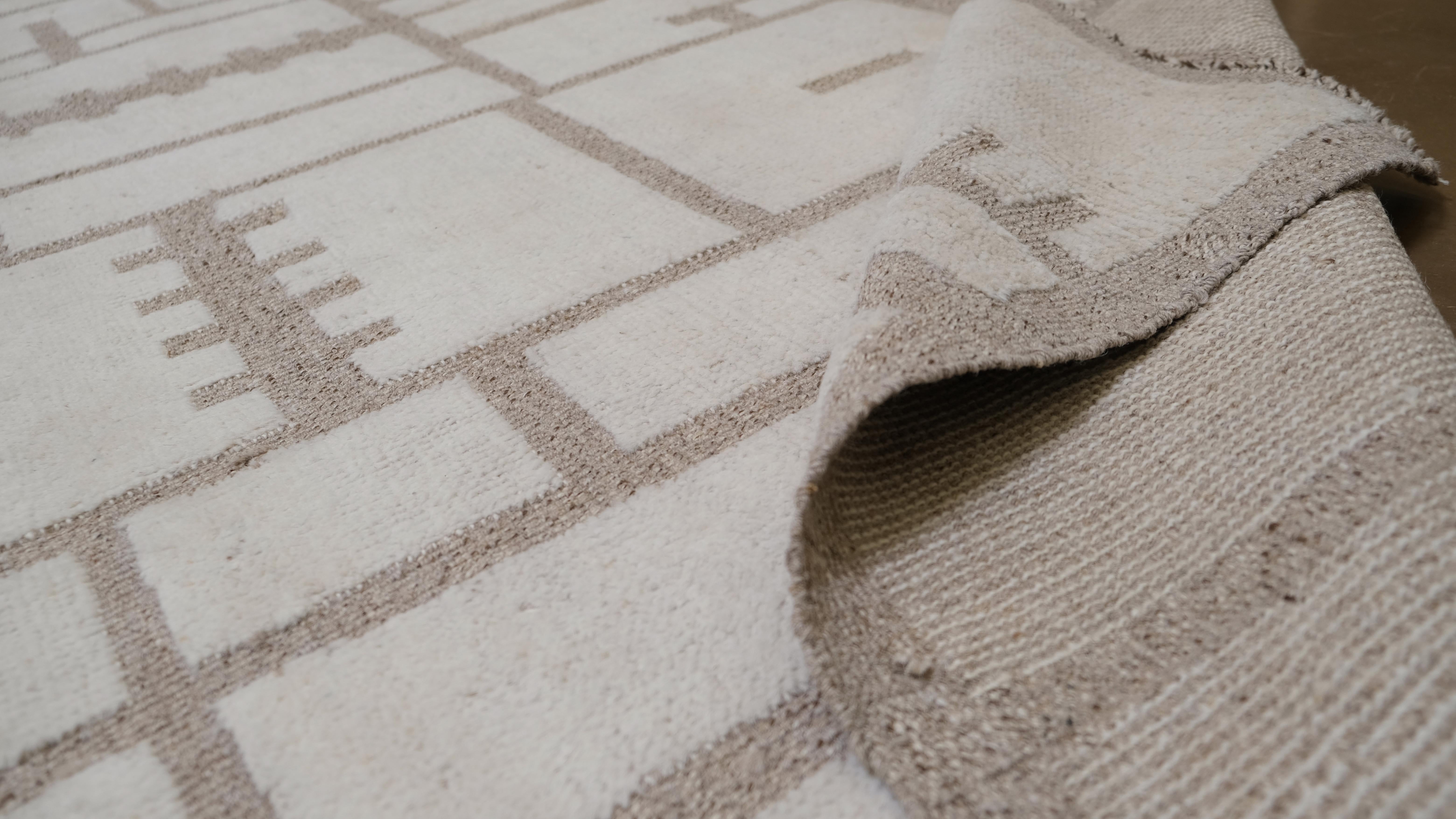 Eleva il tuo spazio con questo sofisticato tappeto in lana annodato a mano proveniente dal Pakistan, caratterizzato da un design geometrico contemporaneo in tonalità beige neutre. Questo pezzo moderno combina un'estetica minimalista con un'intricata