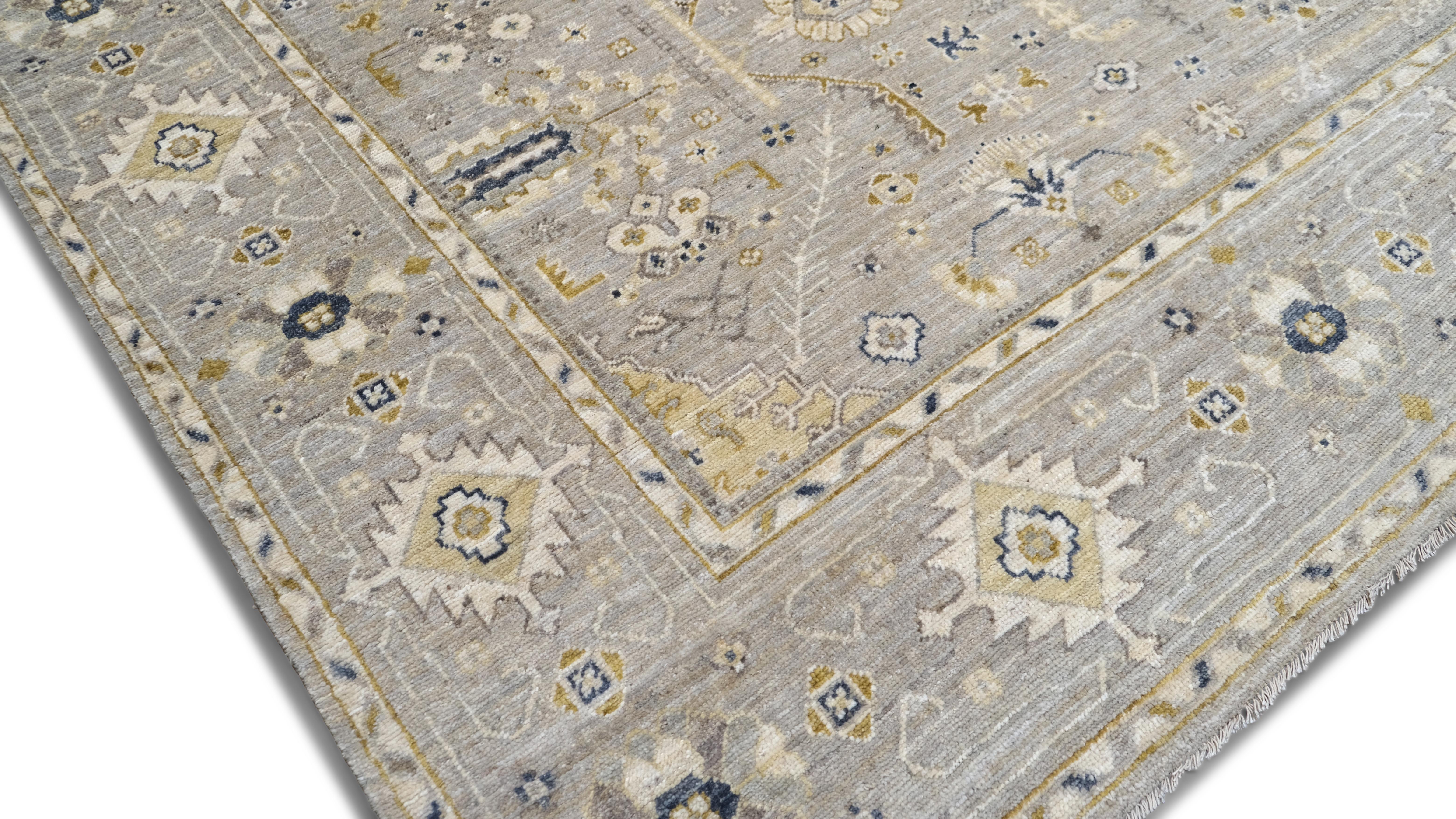 La beauté intemporelle de ce tapis moderne en laine nouée à la main rehausse votre espace de vie. Doté d'un doux design en médaillon gris et beige avec des détails floraux complexes, ce tapis apporte une touche de sophistication et de chaleur à