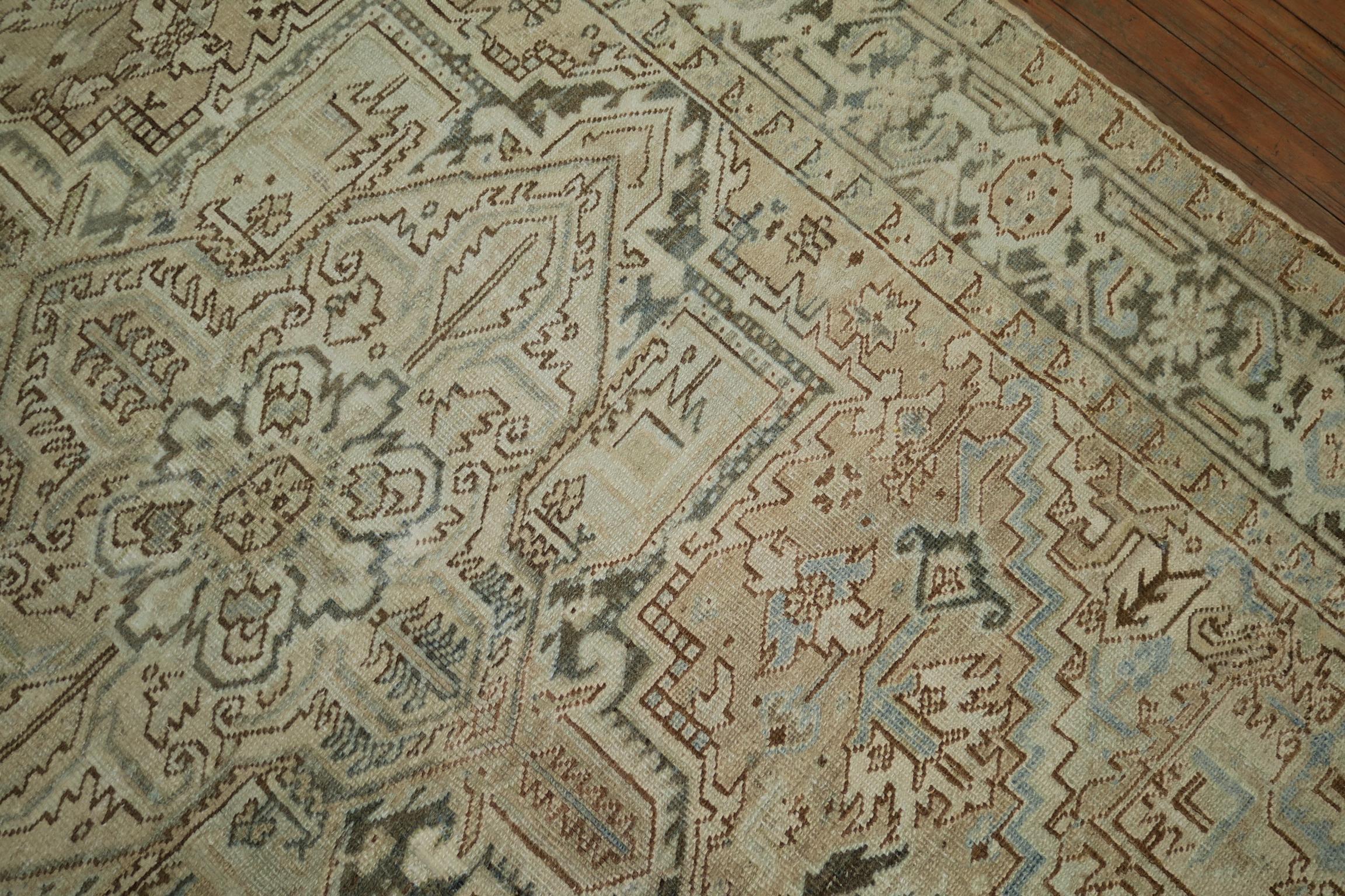 A 20th century traditional Persian Heriz rug in neutral colors. The field is a light beige brown, accents in charcoal, ivory and light blue, circa 1920

Measures: 6' x 8'1”

Heriz carpets are beloved for their versatility. Their geometry