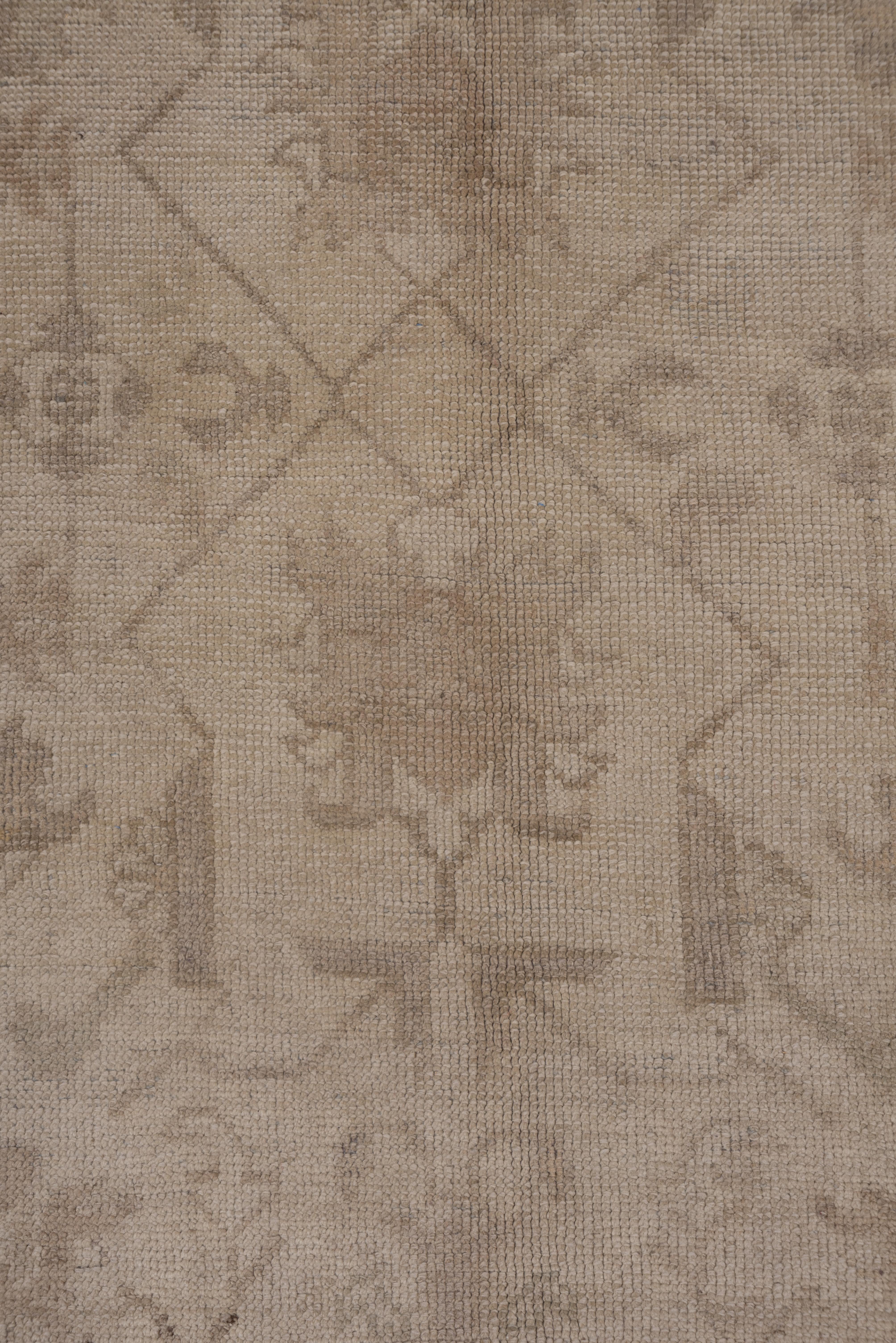 Ce tapis long turc occidental de couleur sable présente un motif de fleurs géométriques et de lianes droites et angulaires de couleur brun clair, entouré de bordures transylvaniennes de style sable du XVIIe siècle, composées de cartouches de couleur