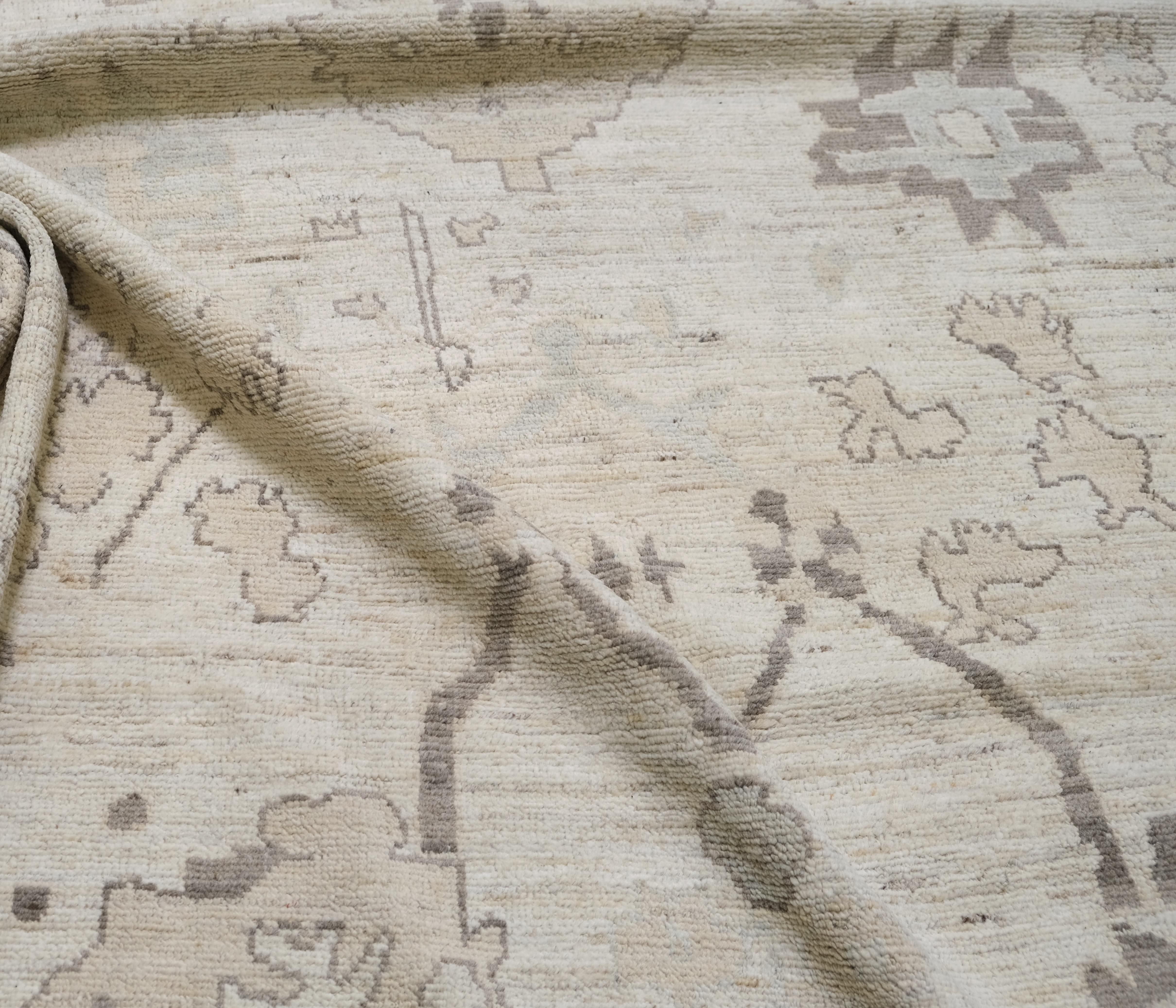 This exquisite hand-knotted wool Oushak rug, showcases a sophisticated blend of traditional artistry and modern neutrality. Measuring approximately 8'3