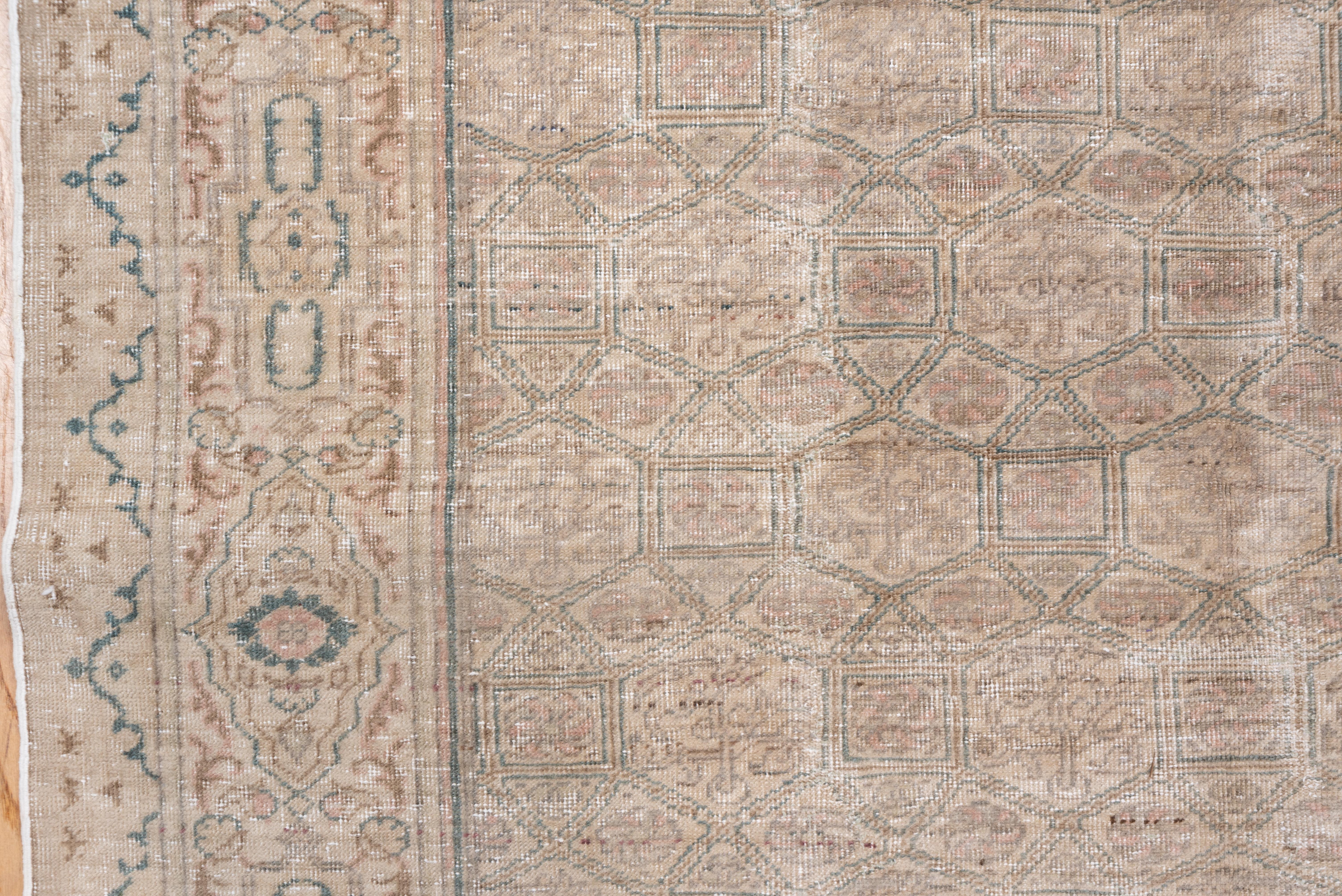 The ecru field displays a lattice of small squares, triangles and rhomboids, with end enclosed rosette and flower design. The beige-ecru border shows cartouches and rosettes. Medium green details. Medium weave. Vertical wear lines.