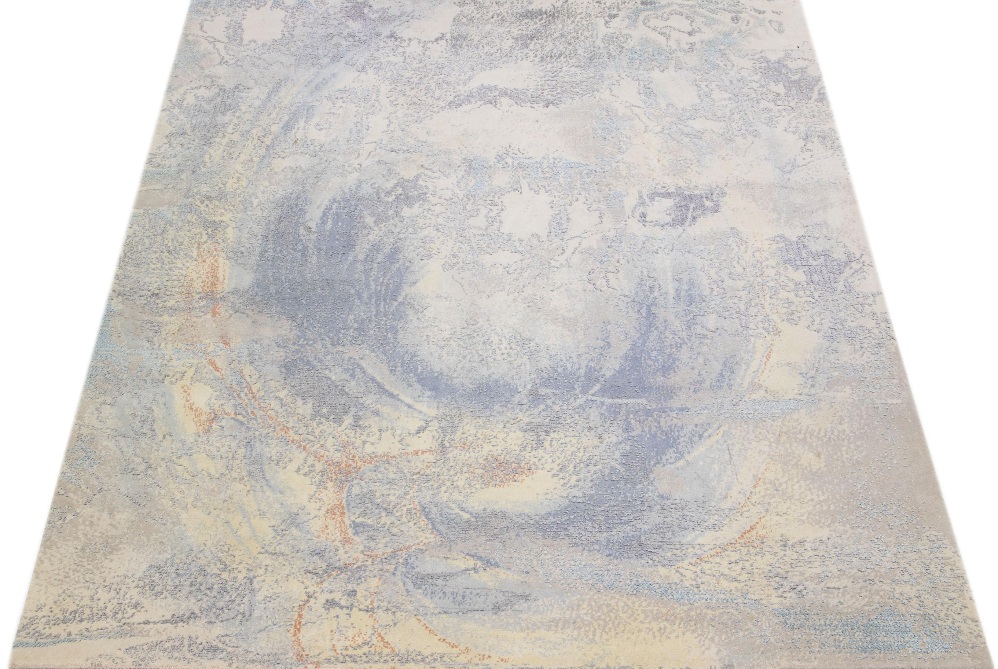 This impressive contemporary rug, handcrafted in India, boasts a meticulous design that blends natural silk and wool materials. The captivating blend of beige tones provides a stunning foundation, while an enchanting abstract motif in natural shades