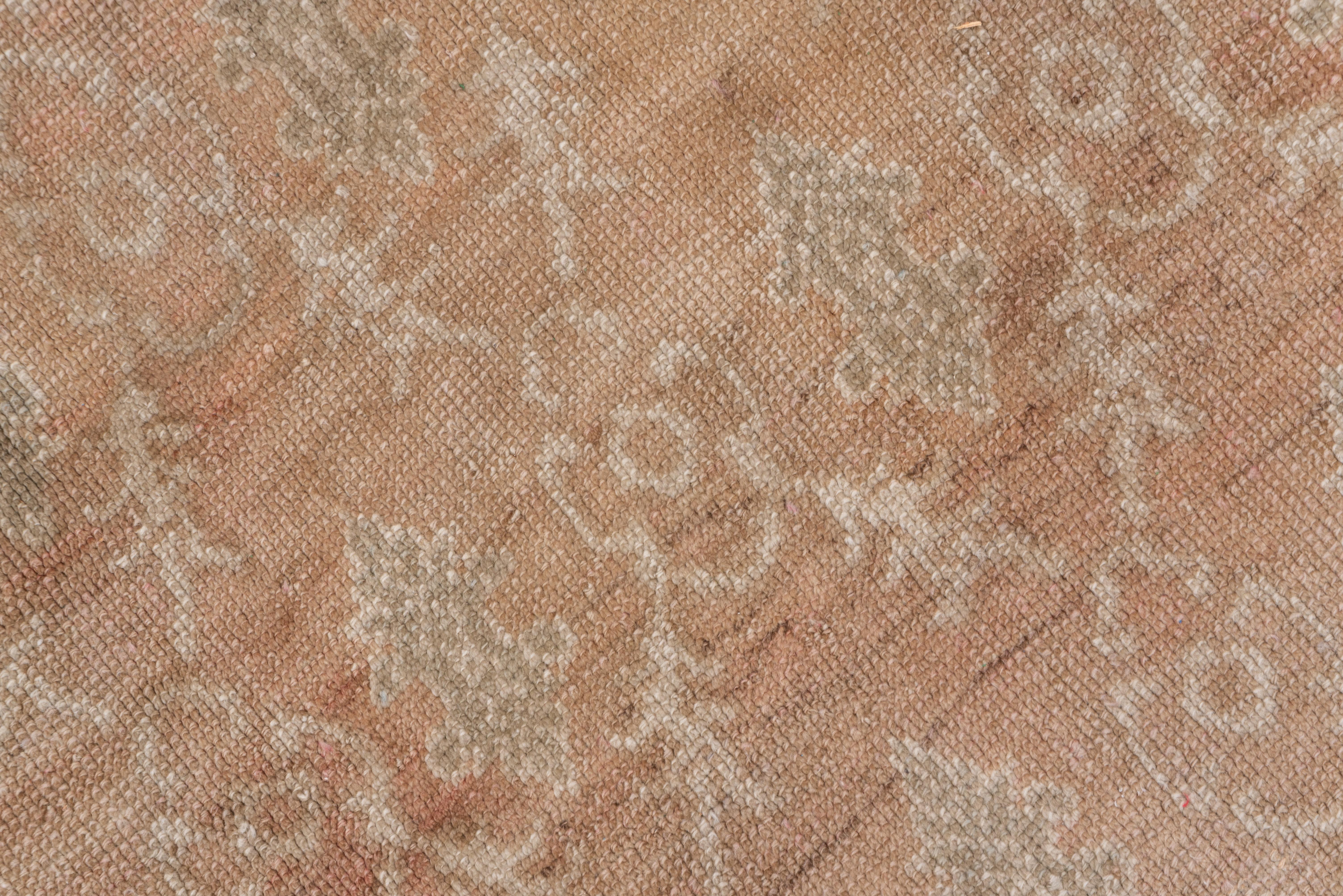 This western Turkish large scatter shows basically two-tone palette in cream and champagne. The pattern of a leafy, lozenge lattice enclosing open palmettes appears on later pieces in the interwar period from central Anatolia, but with stronger