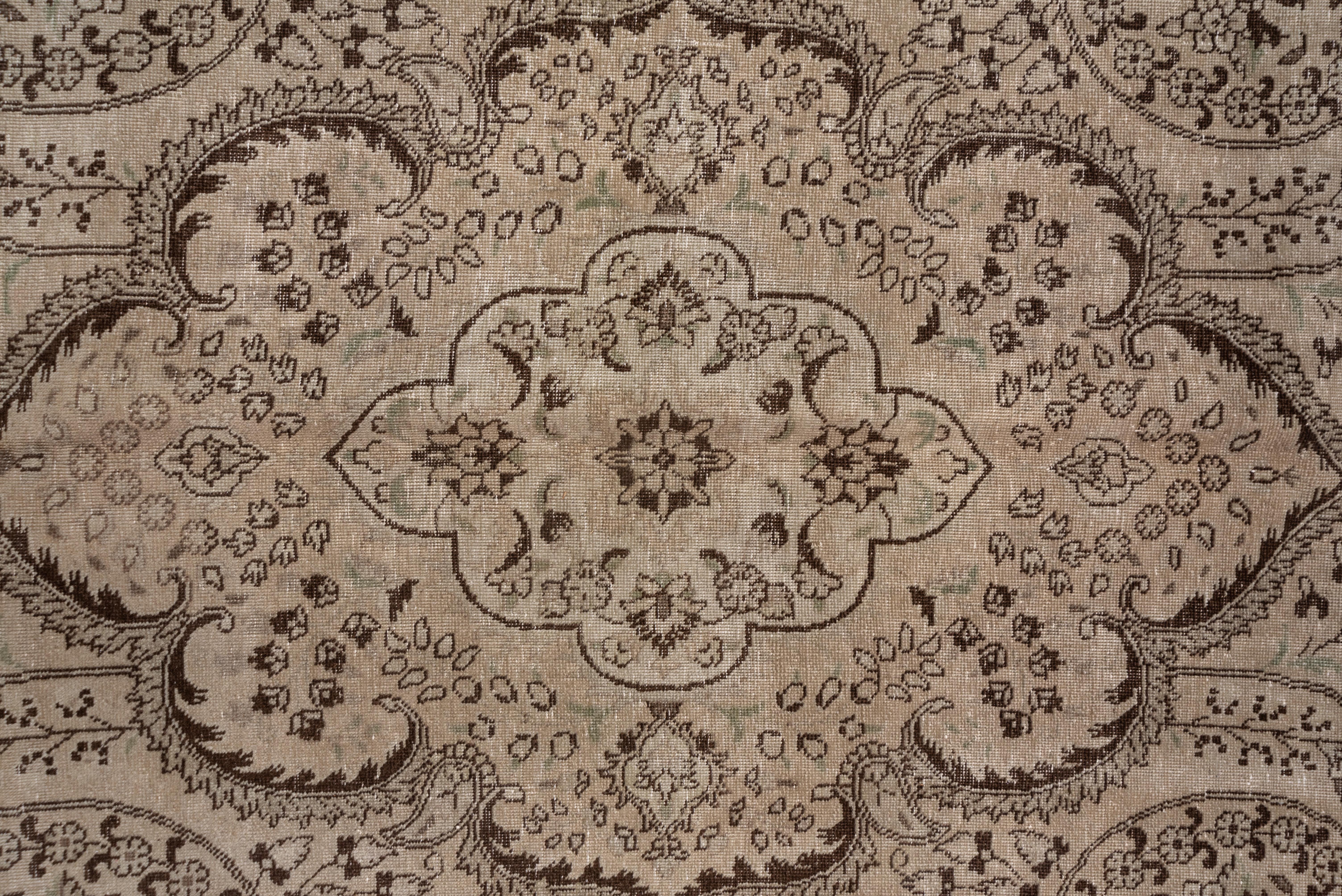 This basically ecru carpet shows leaf and flower coiling volutes around the lappeted oval medallion. The light border of this fair, all-over evenly worn condition eastern Turkish city carpet shows brown-accented tendrils and flowers. Light palette,
