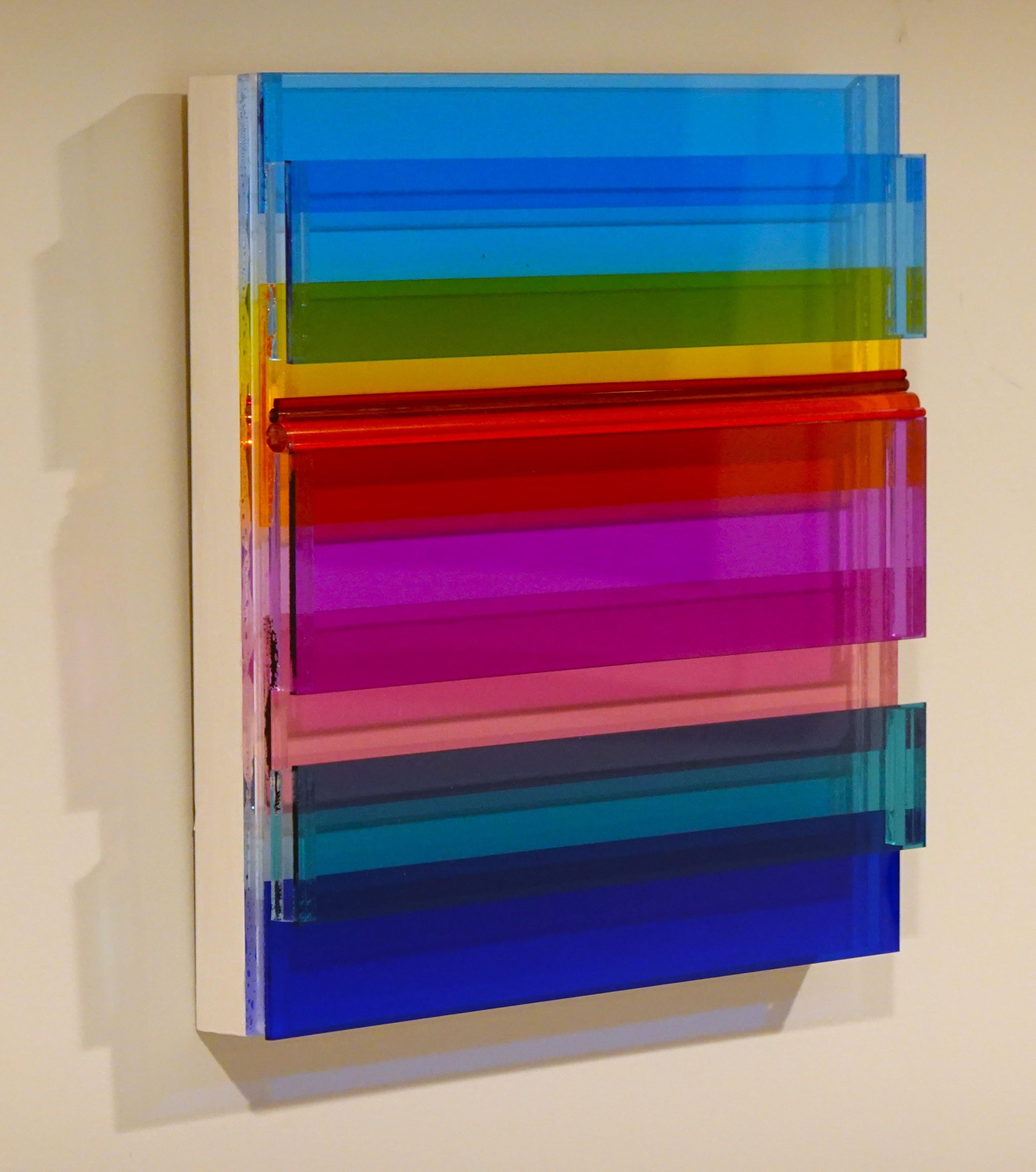 Cielos azules de Neva Setlow está creada con plexiglás de colores en capas, tanto planas como redondas.  Mide 12x12x2 y está llena de colores vivos y dimensión.   Está en un marco de madera y cableado para colgarlo fácilmente.   Es una obra de arte