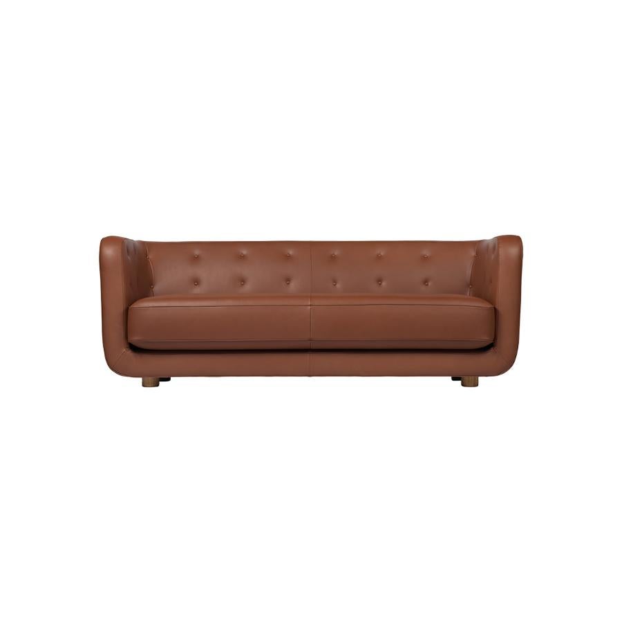 Nevada cognac leather and smoked oak vilhelm sofa by Lassen
Dimensions: W 217 x D 88 x H 80 cm 
Materials: leather, oak.

Vilhelm is a beautiful padded three-seater sofa designed by Flemming Lassen in 1935. A sofa must be able to function in several