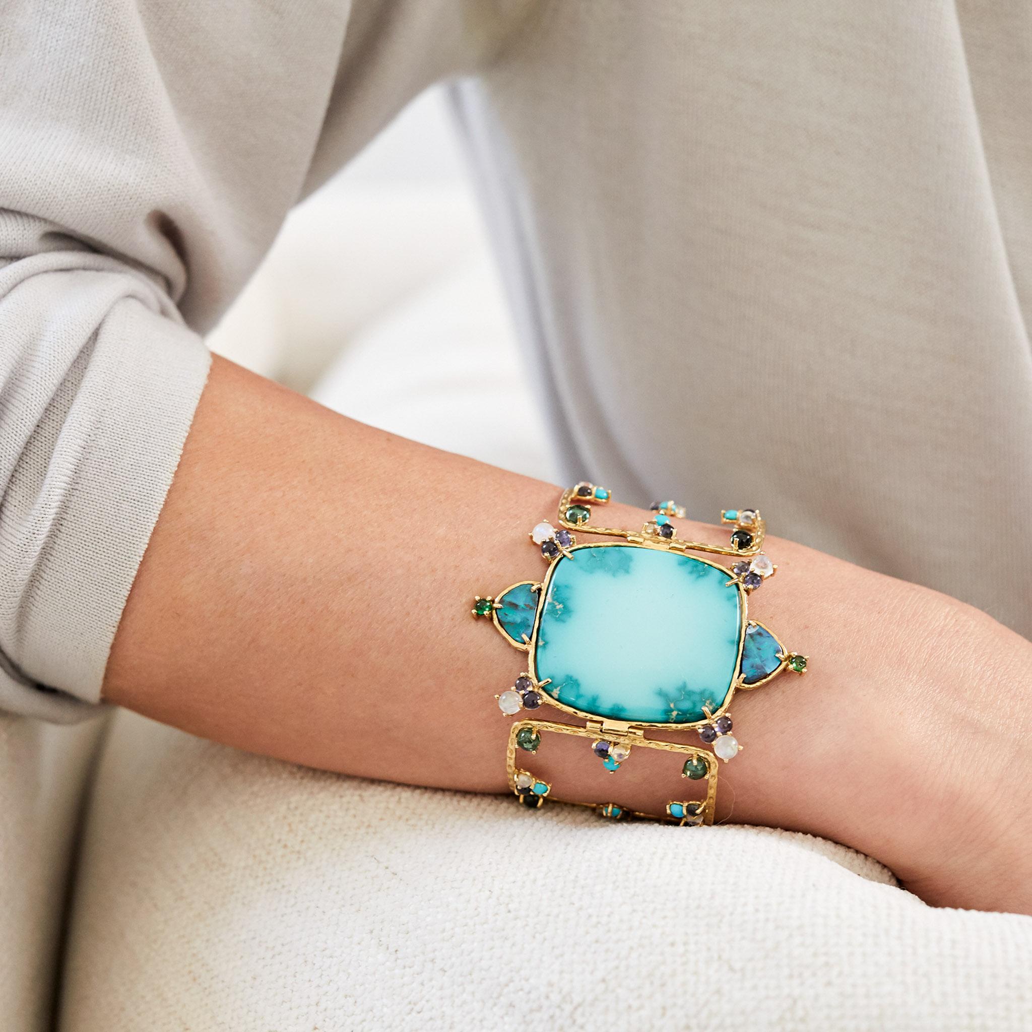 A rare and stunning slab of antique Nevada turquoise anchors this eye-catching bracelet by Daria de Koning. Set in between open-work panels of our signature marquise-engraved 18k yellow gold that are studded with cabochons of green tourmaline,