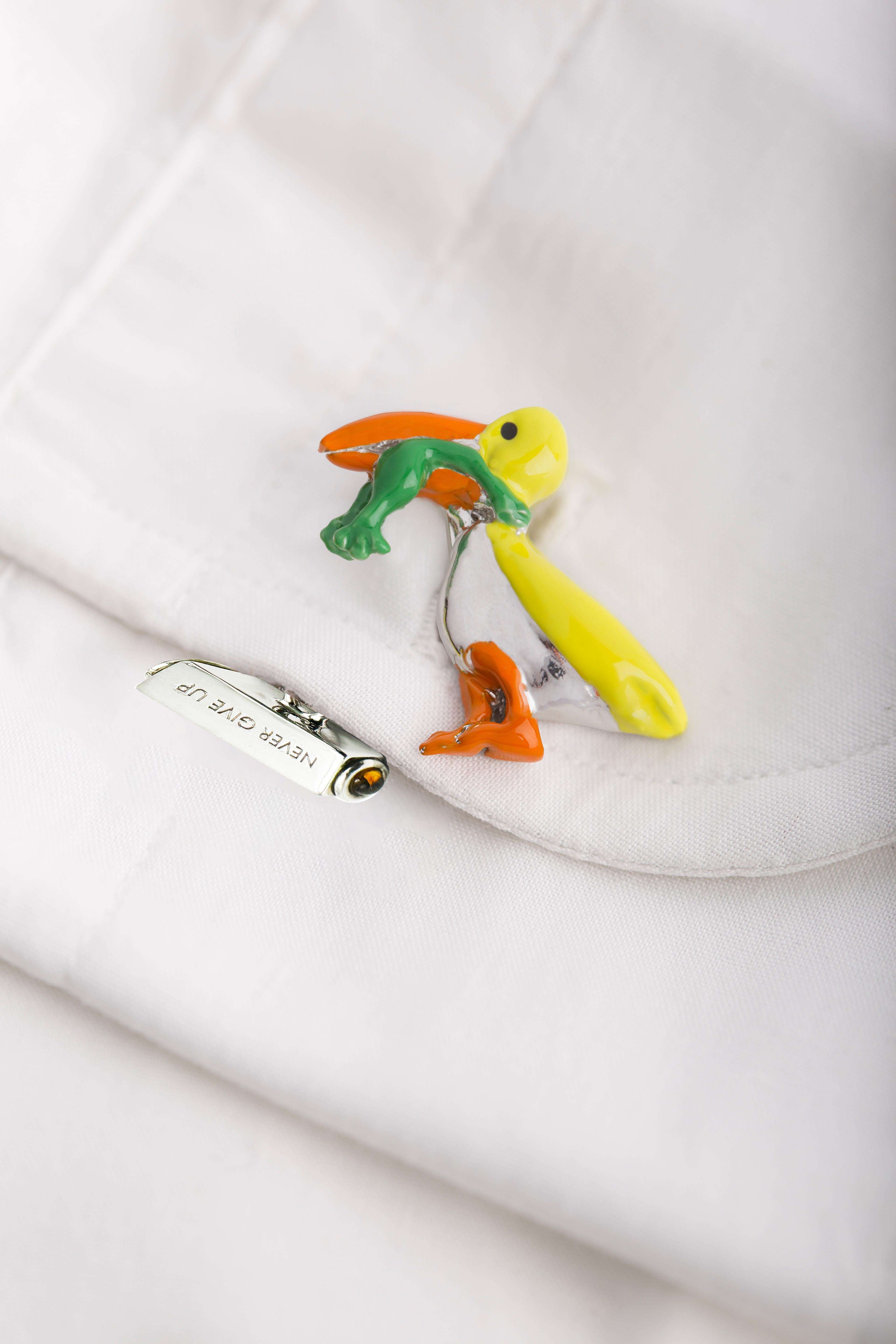 Never Give Up Boutons de manchette pour homme au design unique, ornés de tourmaline citrine et d'émaux colorés sur argent sterling plaqué rhodium.
Drôles de boutons de manchette faits à la main représentant un pélican mangeant une grenouille qui, à