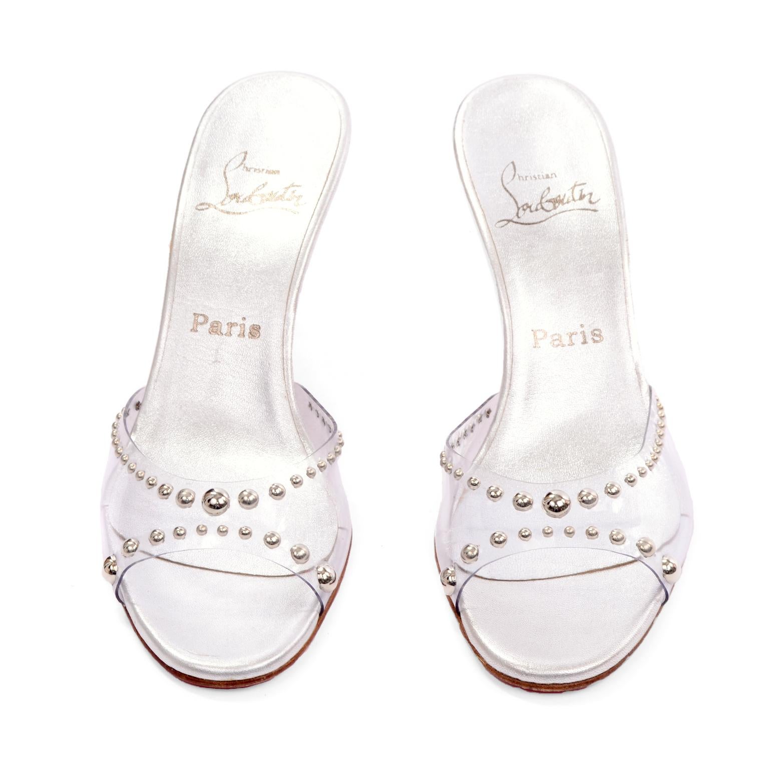 These are wonderful Christian Louboutin heels with pvc clear uppers embellished with silver round studs that were never worn. These open toe slides have 3 inch heels and a silver metallic insole. The classic Louboutin red soles are in beautiful