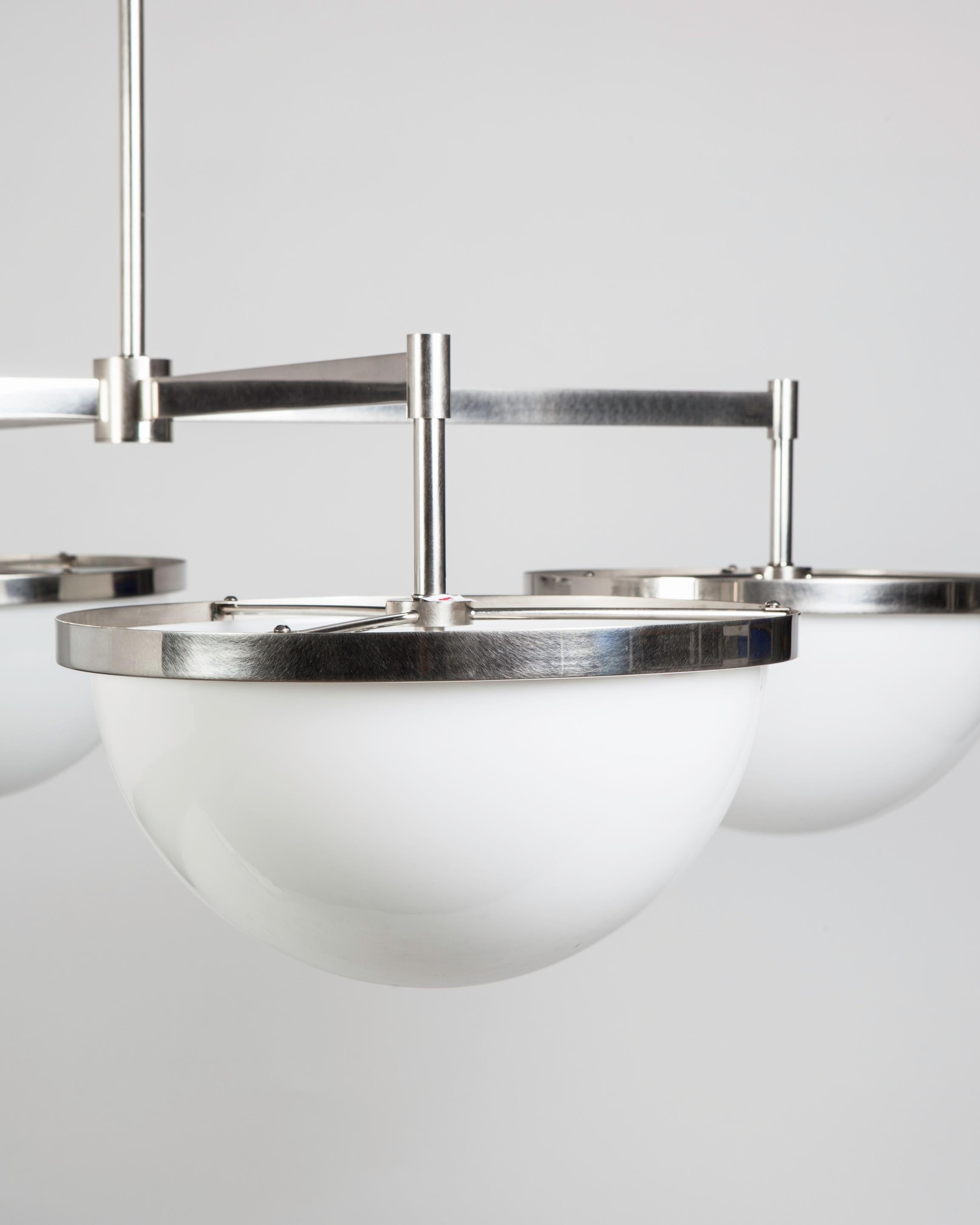 WHL2227.14
Designed by Alan Wanzenberg for Remains Lighting, the four arm Nevins 14 chandelier is the most simple and elemental of fixtures; with a set of four pure milk glass domes suspended in ribbons of unadorned metal, with rectangular
