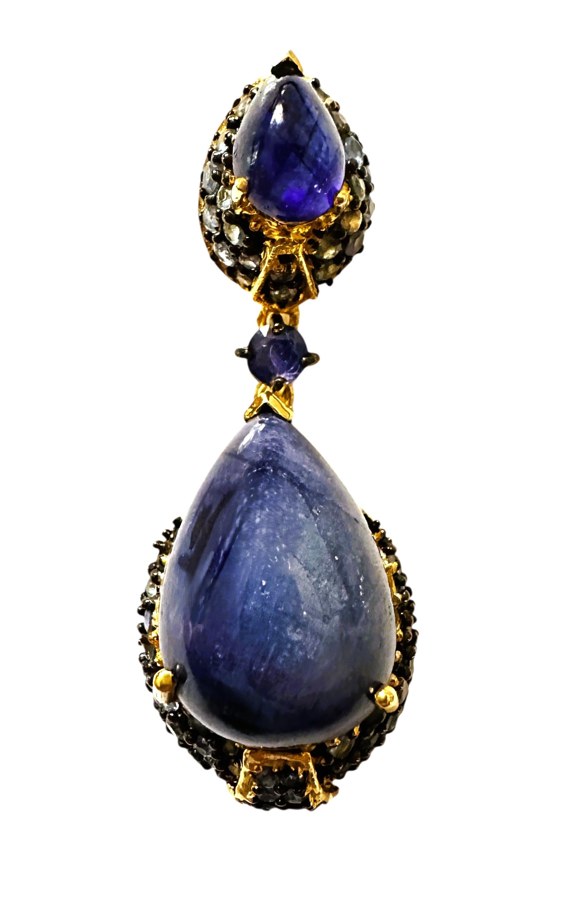 ¡Este colgante es simplemente extraordinario y magnífico!  Las piedras son naturales y todas resultan ser zafiros.  Tiene 2 cabujones en forma de pera y zafiros talla diamante alrededor de ellos, todo ello en un engaste chapado en oro de 18k.  El