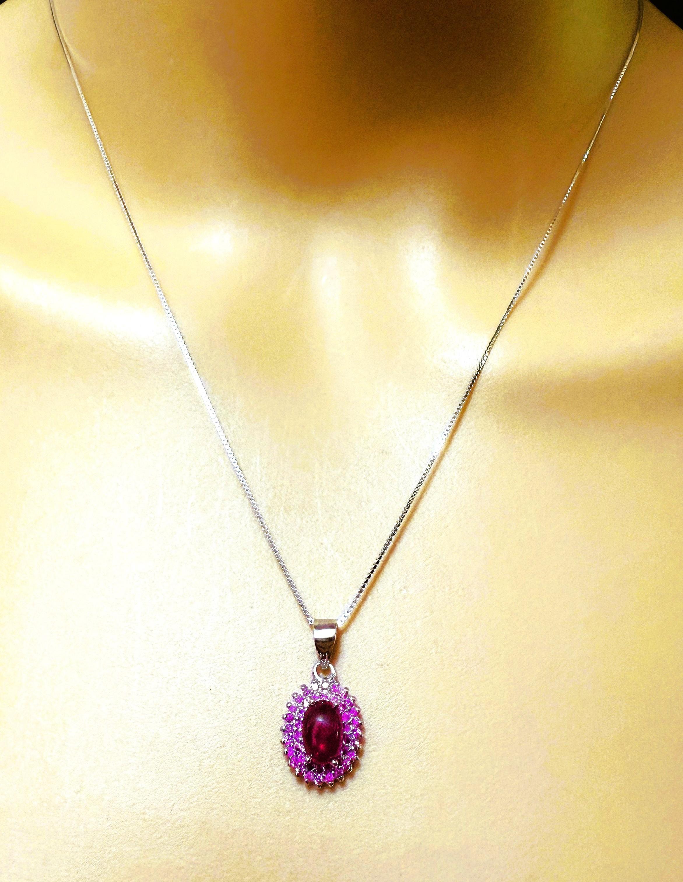 Questa collana è davvero bellissima.  Ha una pietra cabochon di rubino 7 x 5 x 3 per un totale di 1,14 carati.  La pietra proviene dal Madagascar.  È circondato da rubini con taglio a diamante.    Il ciondolo stesso misura 12,2 x 10,2 mm.  È montato