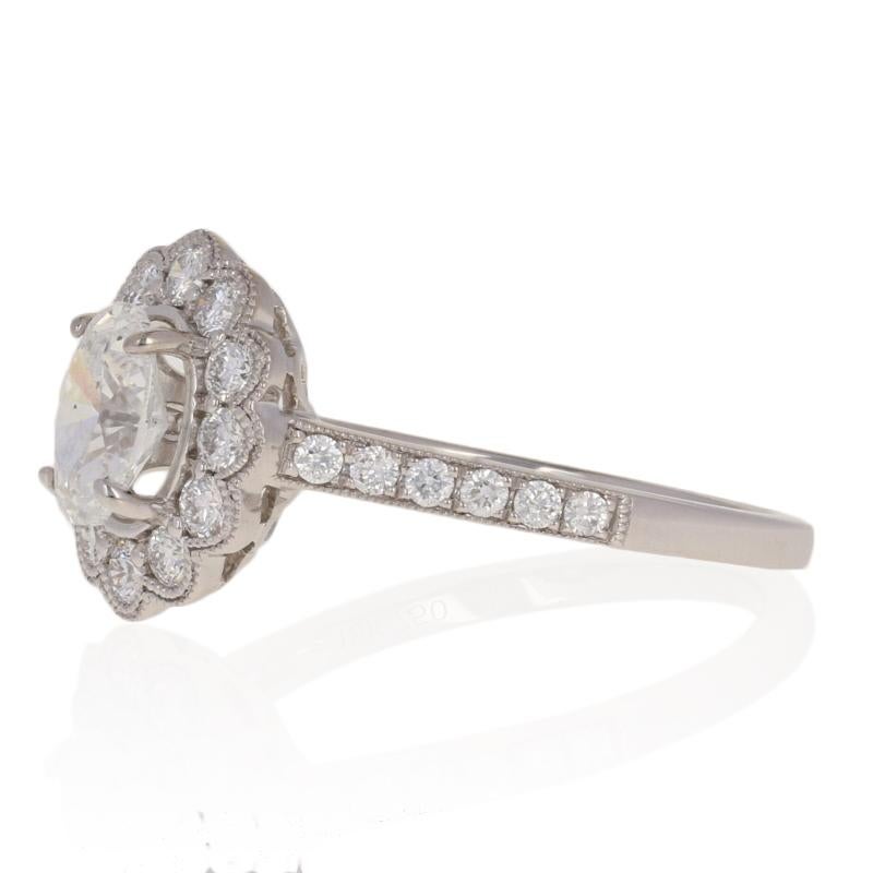 Breathtakingly beautiful, this NEW engagement piece will be an exquisite choice for your bride-to-be! This 18k white gold floral halo ring showcases a GIA-graded diamond solitaire sweetly accompanied by a sparkling array of diamond accents and