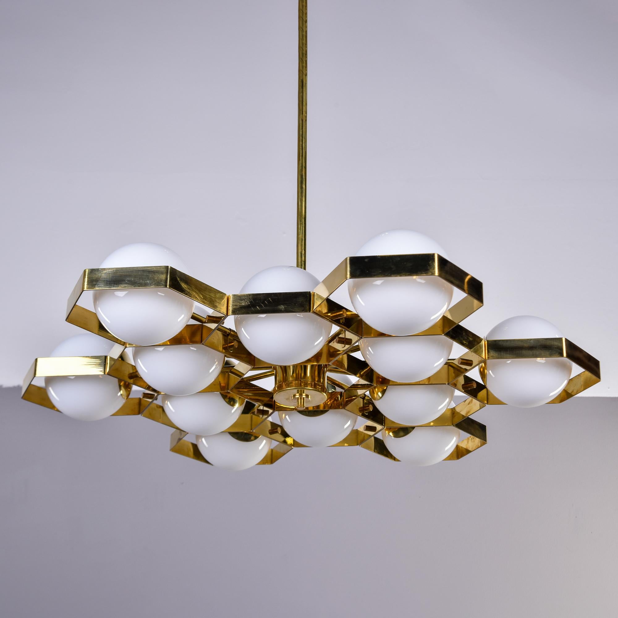 New and made for us in Italy, this 12 light fixture has a polished brass honeycomb-style frame with white glass globes. Each globe contains a single, candelabra style socket. Height shown includes brass suspension rod which can be shortened by your