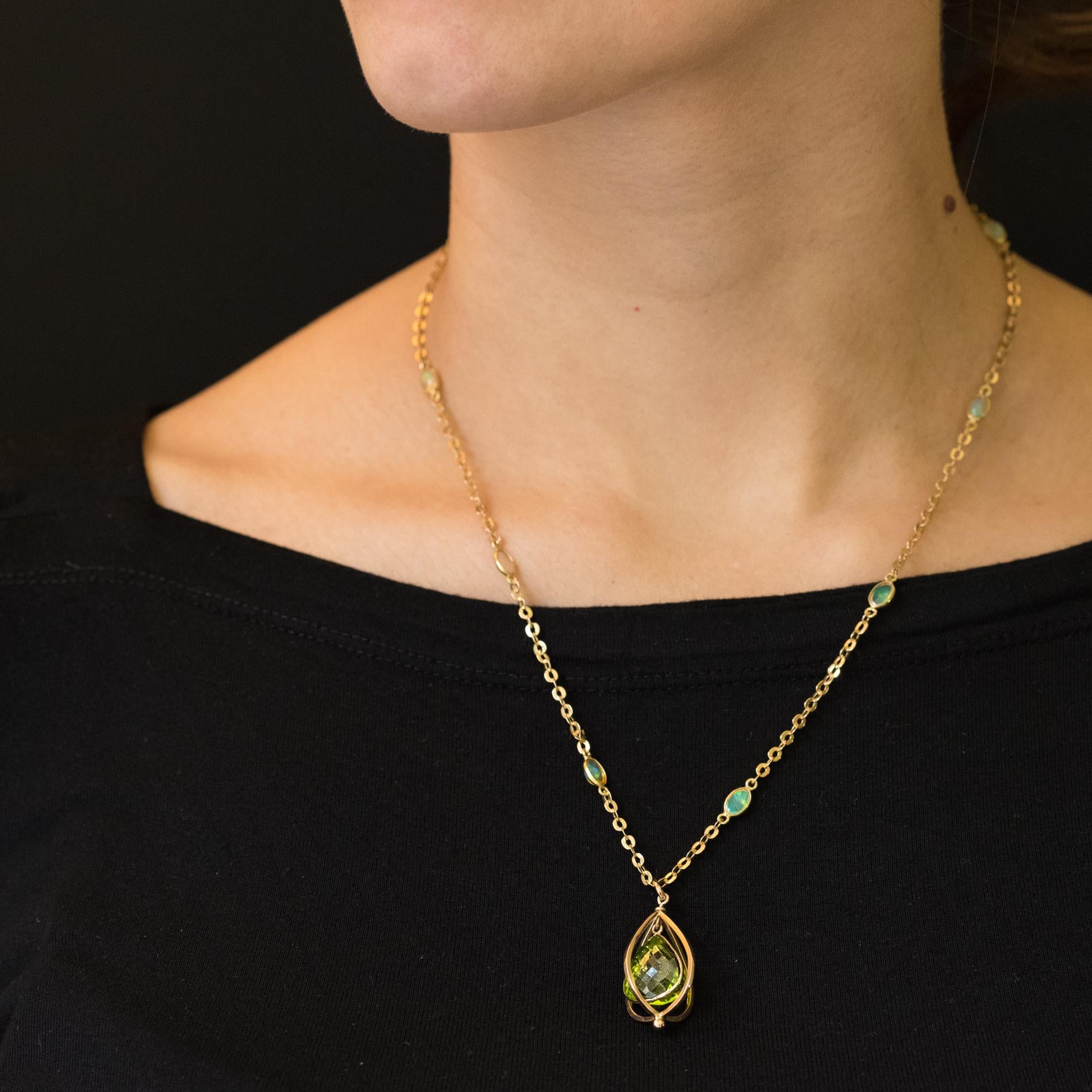 Unique piece.
Necklace in 18 Karats yellow gold, eagle's head hallmark.
Splendid and original necklace, it is made up of a flattened convolute mesh punctuated with opals cabochons in closed setting which retains a pendant consisting of a gold cage