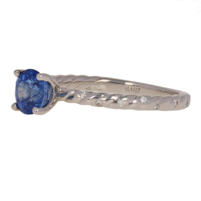 Two hearts. One cherished love story. Elegantly crafted in 14k white gold, this NEW engagement ring hosts a satin blue sapphire accompanied by sparkling diamonds which cascade down the ring’s rope-textured shoulders. 

This ring is a size 7, but it