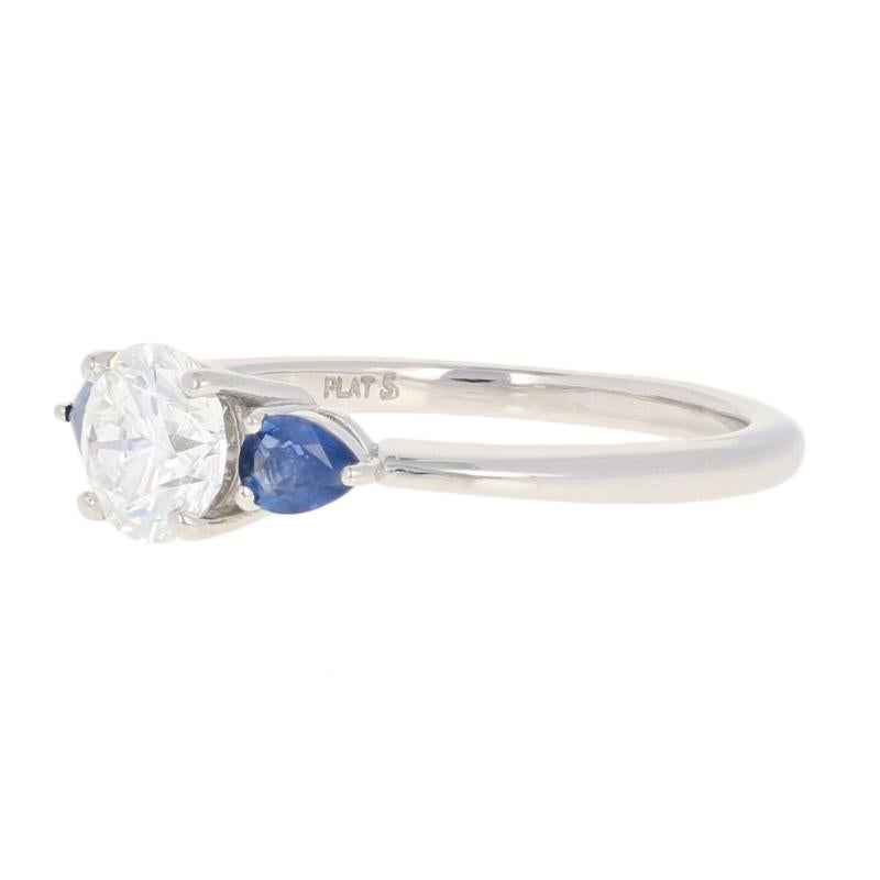 Make your proposal even more special by giving your sweetheart her dream engagement ring! Featuring a classically elegant silhouette, this NEW ring hosts a GIA-graded diamond solitaire that is accompanied by two satiny blue sapphires and showcased