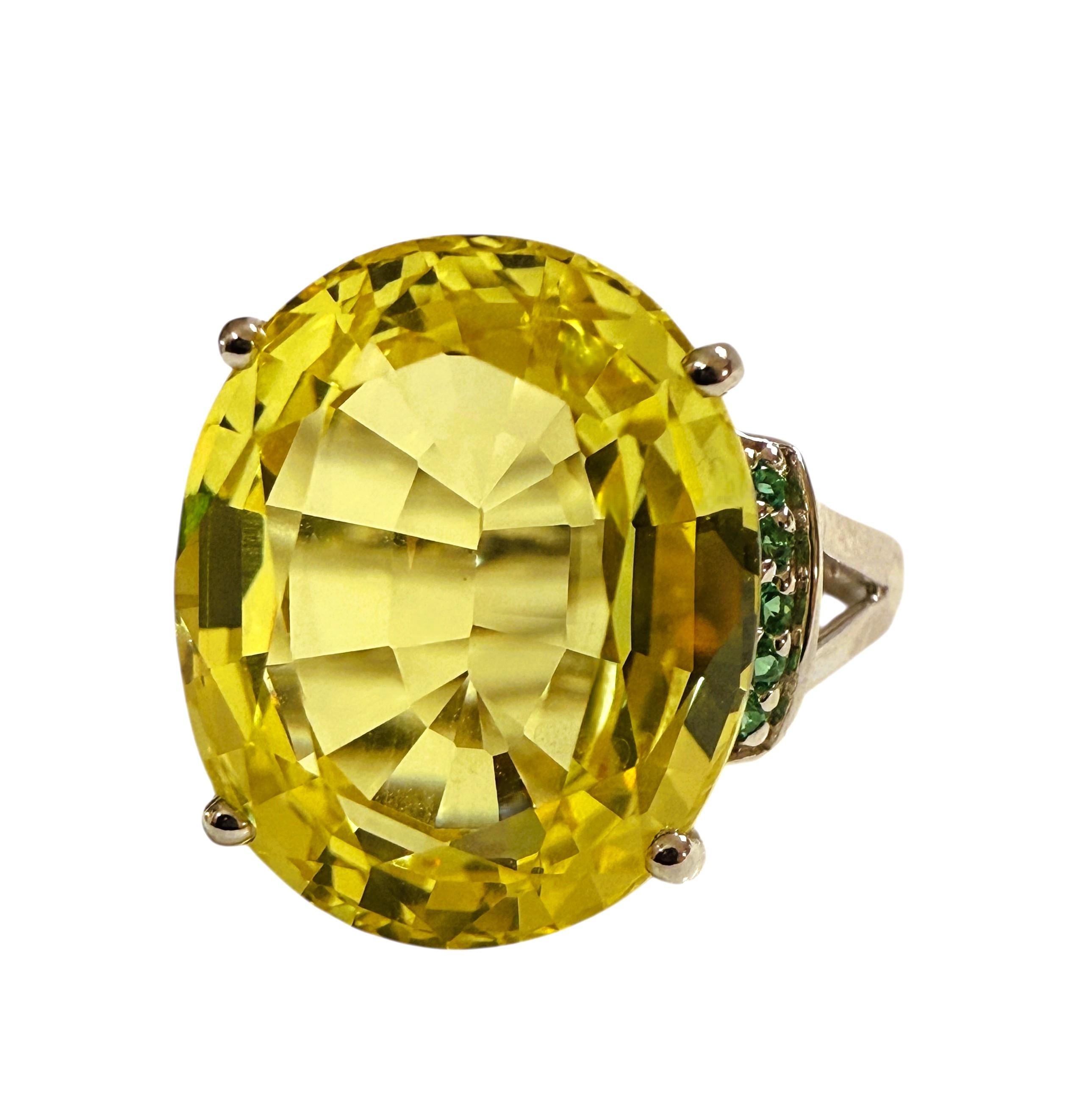 Was für ein wunderschöner Ring!  Der Stein stammt aus Afrika und hat einen schönen gelben Farbton.  Der Ring hat die Größe 7.   Der Stein ist oval geschliffen und hat 14.8 Karat.  Er misst 15,5 x 12,7 mm und wird von schönen grünen Tsavorit-Steinen