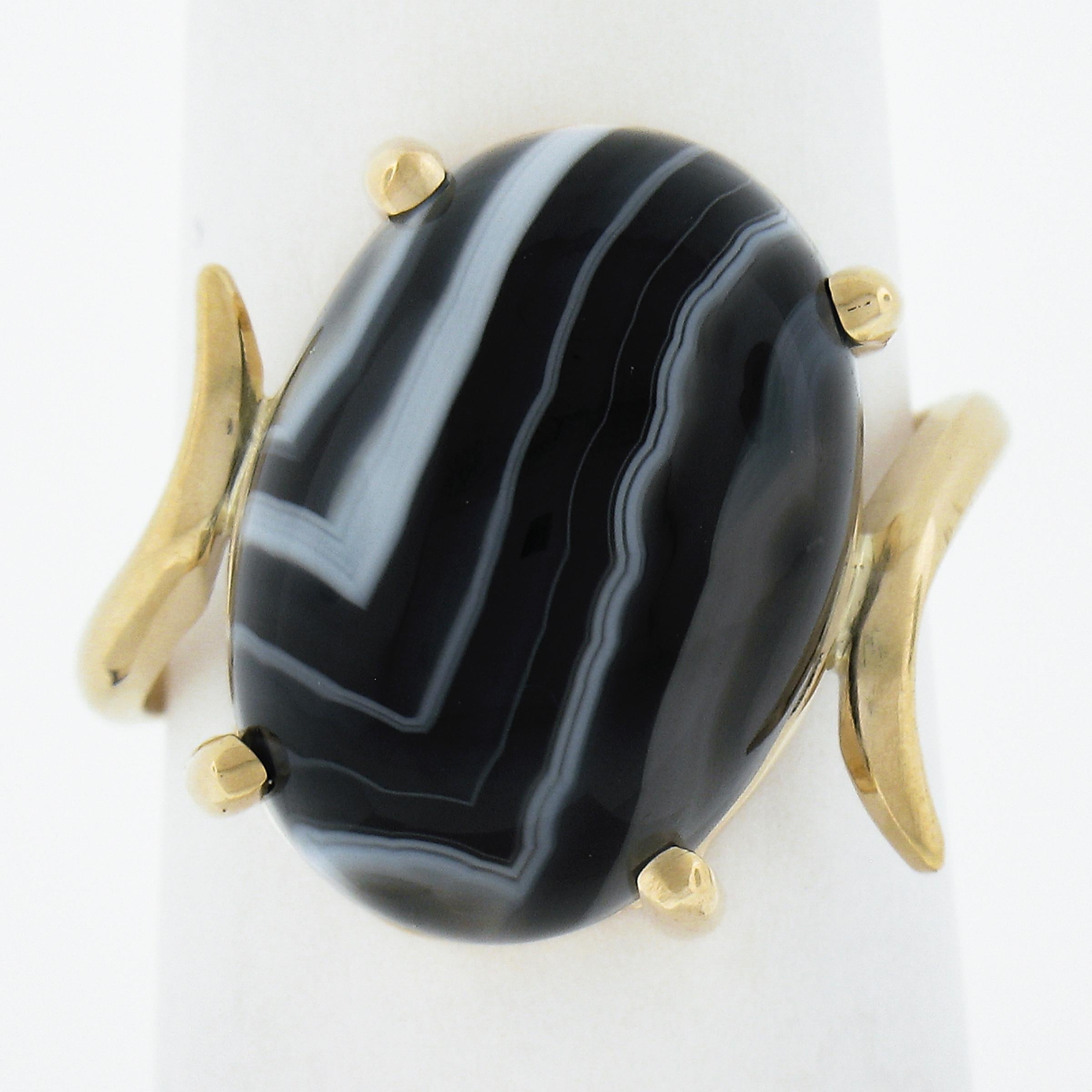 --Stone(s):--
(1) Natural Genuine Agate - Oval Cabochon Cut - Prong Set - Black Color with White banded Lines - 18.2x13mm (approx.)

Material: Solid 14K Yellow Gold
Weight: 5.52 Grams
Ring Size: 8.0 (Fitted on a finger. We can custom size this ring