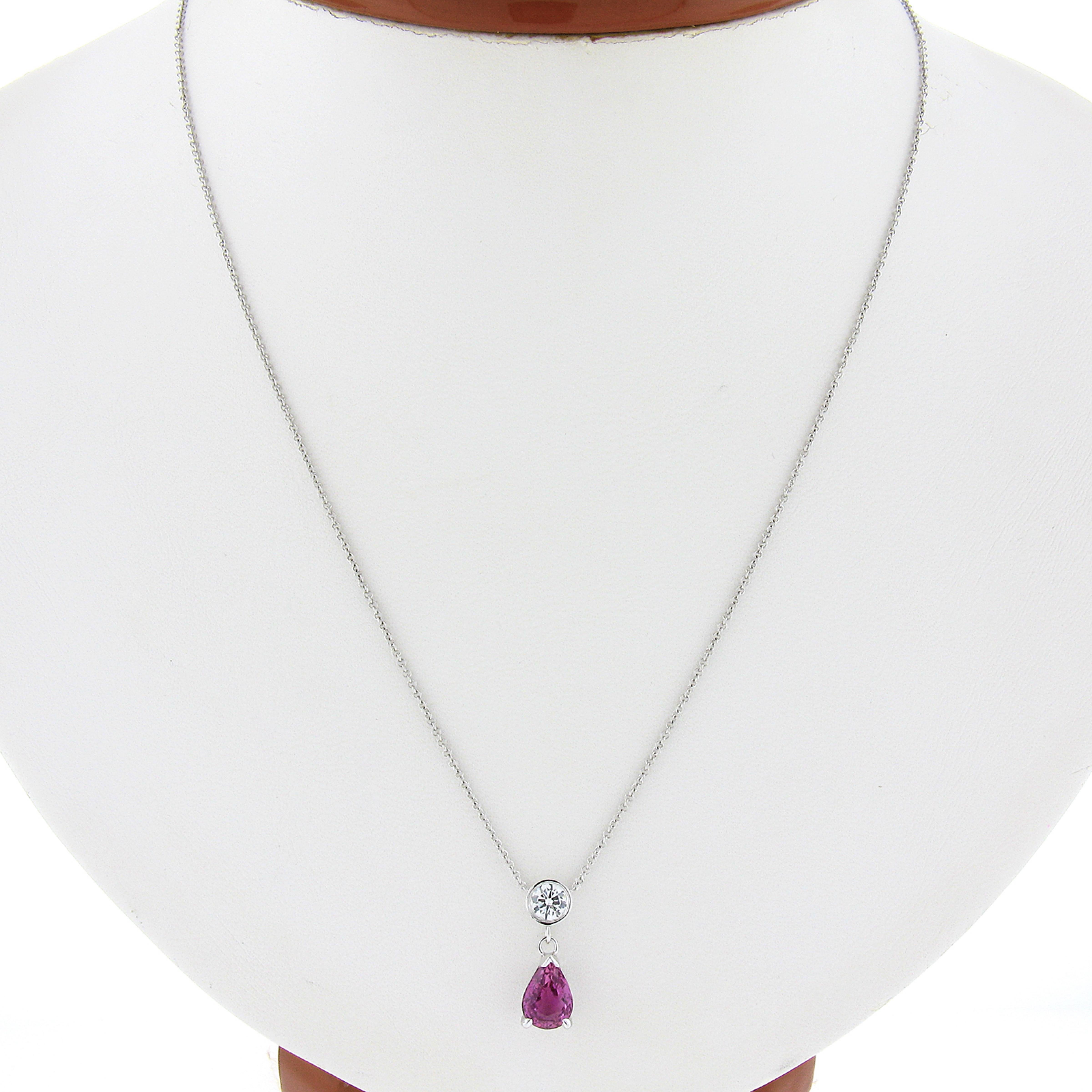 This amazing pendant necklace is newly crafted in solid 14k white gold featuring an outstanding drop dangle design with a fine diamond and sapphire stone. The pear cut sapphire is neatly prong set in an open basket setting, and stands out with its