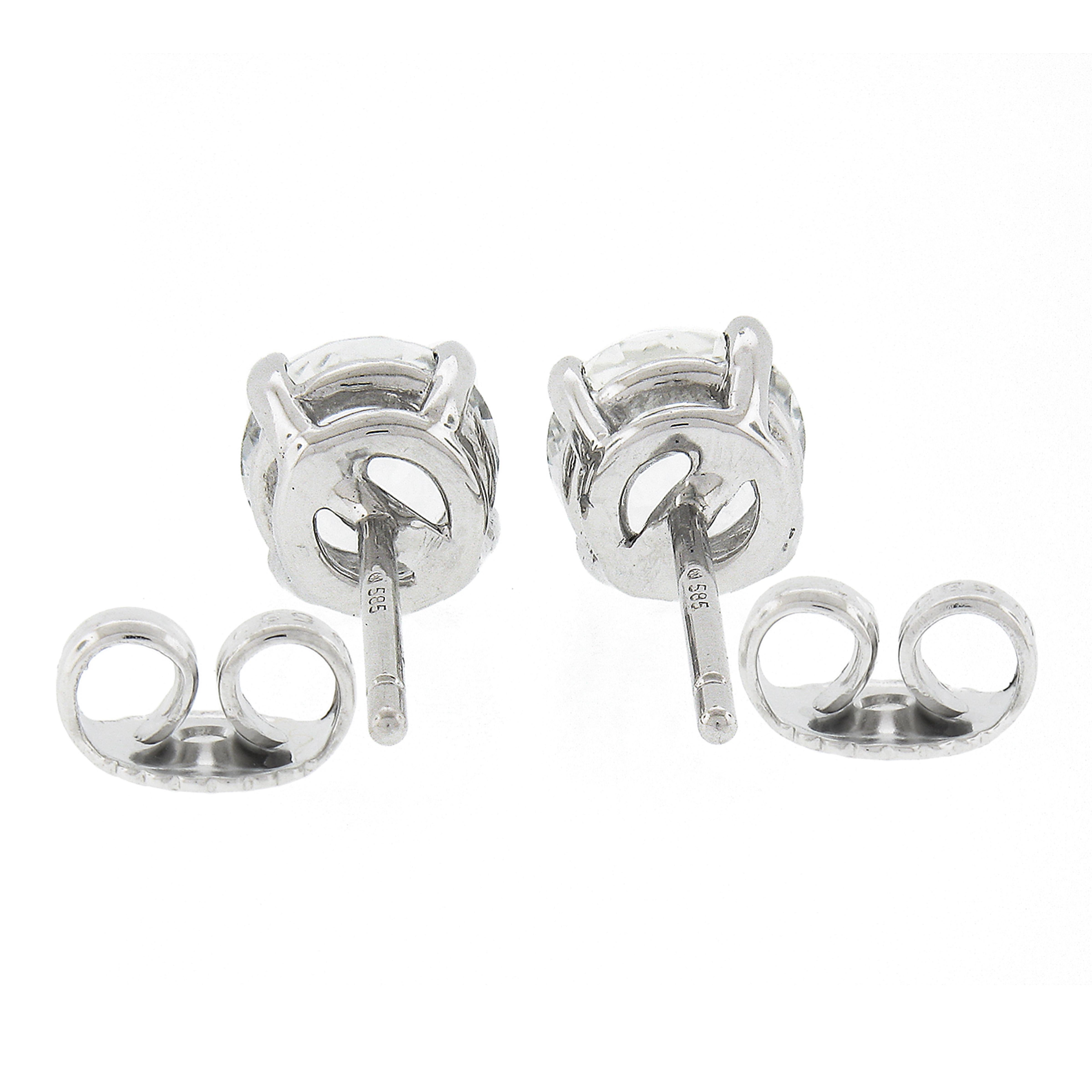 Cette magnifique paire de boucles d'oreilles en saphir blanc a été récemment fabriquée en or blanc massif 14k et présente deux saphirs exceptionnellement brillants, certifiés GIA, de taille ronde et brillante. Les saphirs pèsent environ 2,21 carats