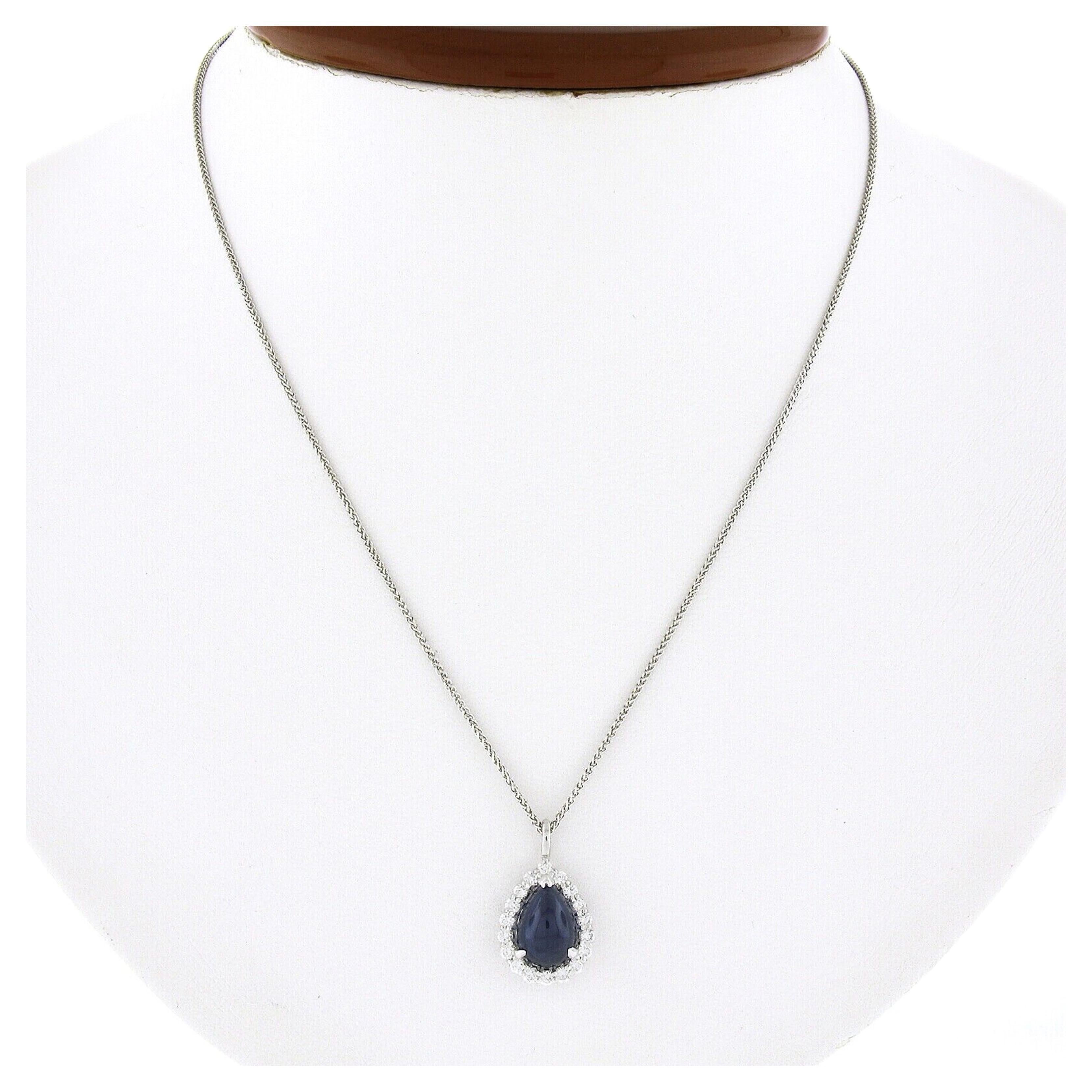 Here we have a gorgeous sapphire and diamond teardrop pendant necklace that is newly crafted in solid 14k white gold. The fine quality sapphire solitaire is Gubelin certified with a pear cabochon cut, displaying the most attractive, and truly rich,
