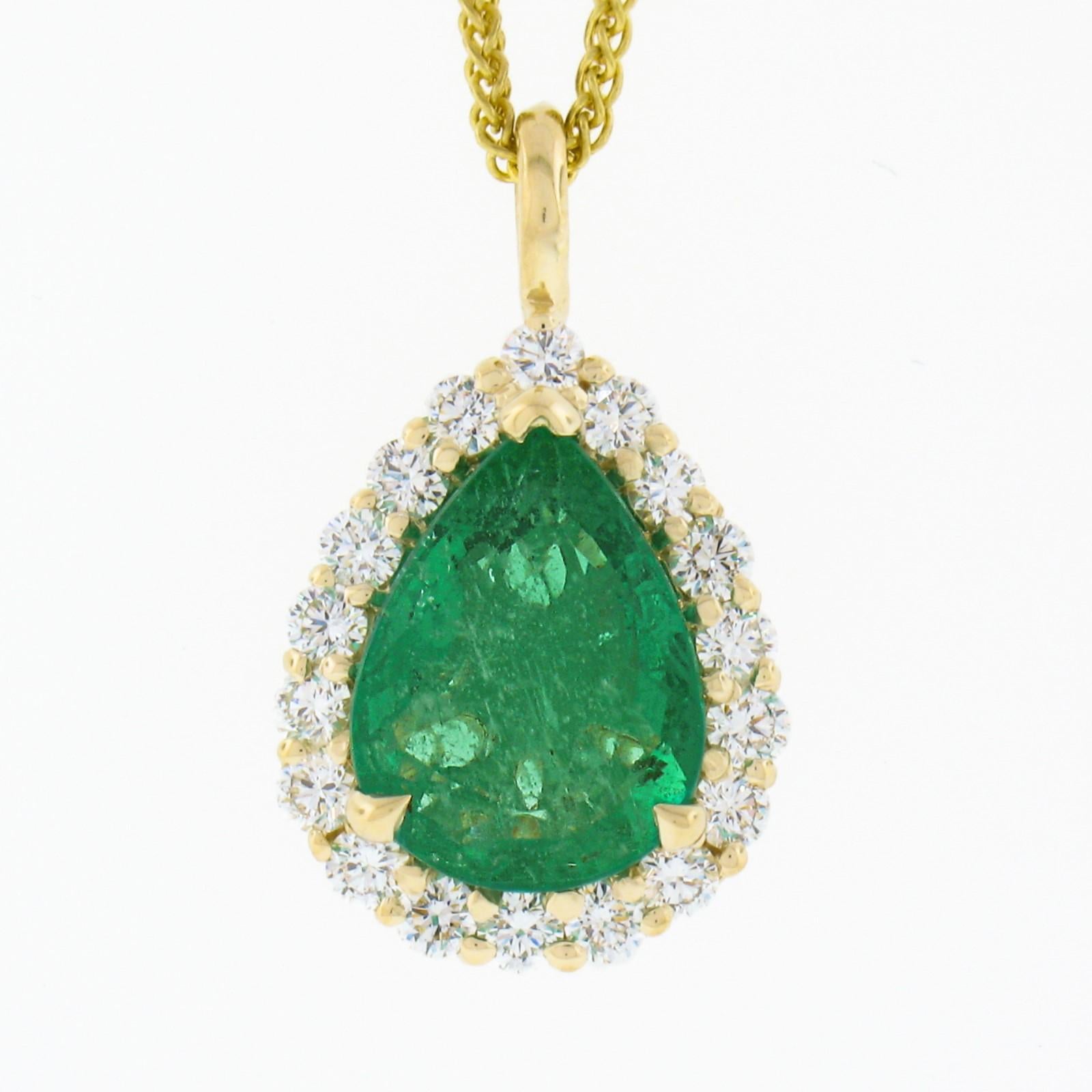 Here we have a gorgeous, custom made, emerald and diamond teardrop pendant necklace that is newly crafted in solid 14k yellow gold. The very fine quality emerald solitaire is SSEF certified with a pear brilliant cut, displaying the most attractive