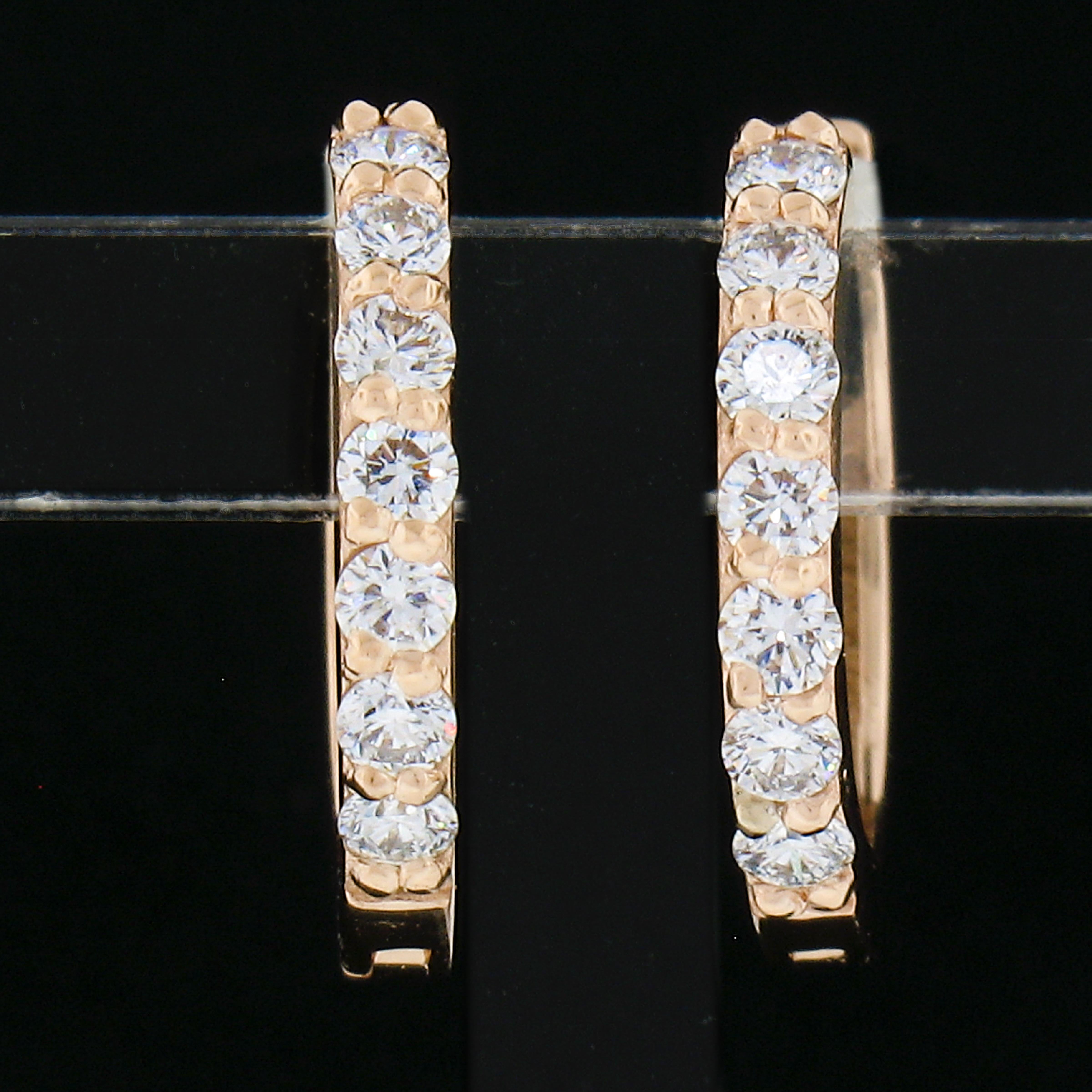 This classic and brilliant pair of petite hoop earrings was newly crafted from solid 14k rose gold and features exactly 0.28 carats of round brilliant cut diamonds. The petite diamonds sparkle very brilliantly and are pave set across the front side