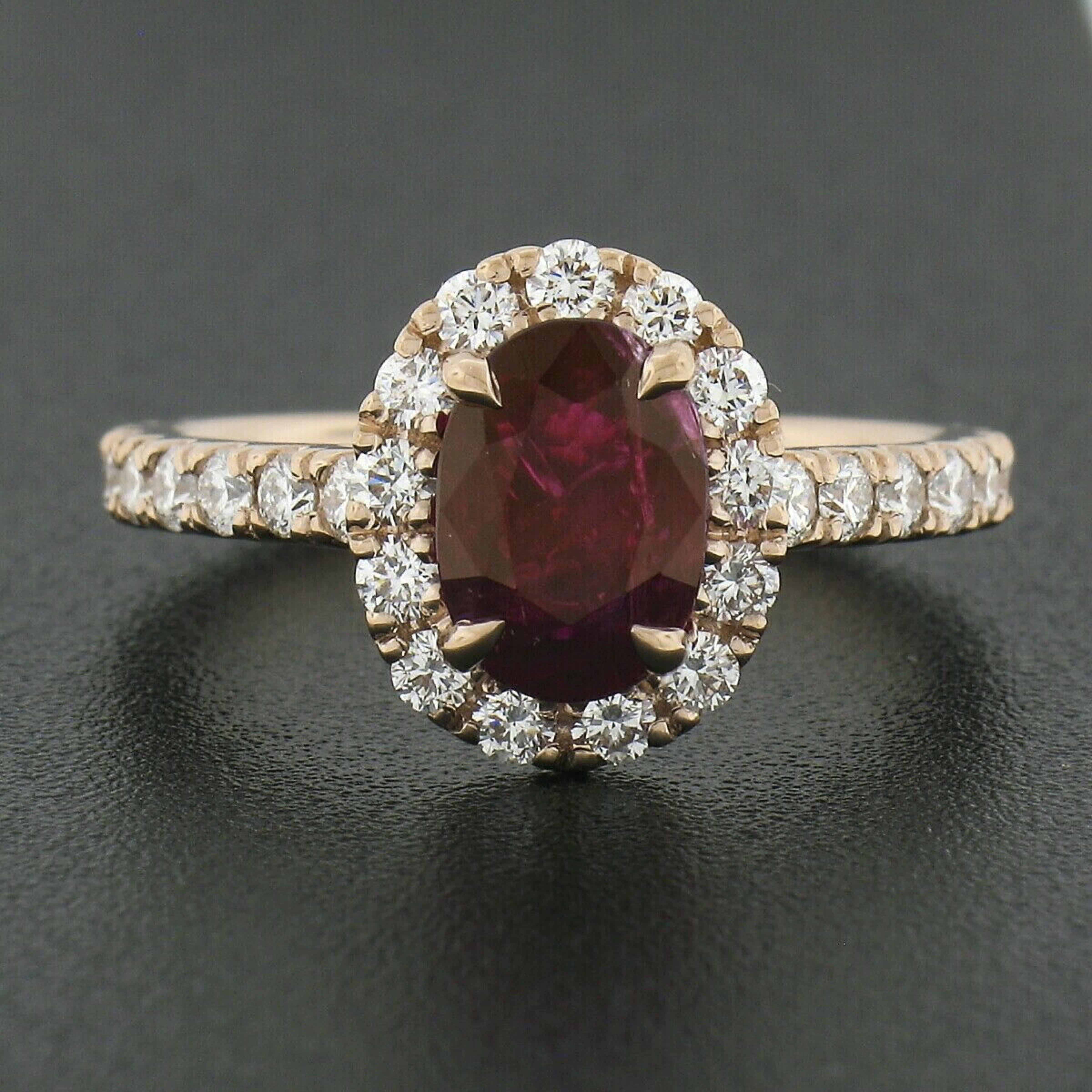 This elegant brand new ruby and diamond ring is crafted in solid 14k rose gold and features a GIA certified natural ruby stone weighing exactly 2.34 carats and displaying a truly gorgeous and deep red color. The fine ruby has an oval brilliant cut