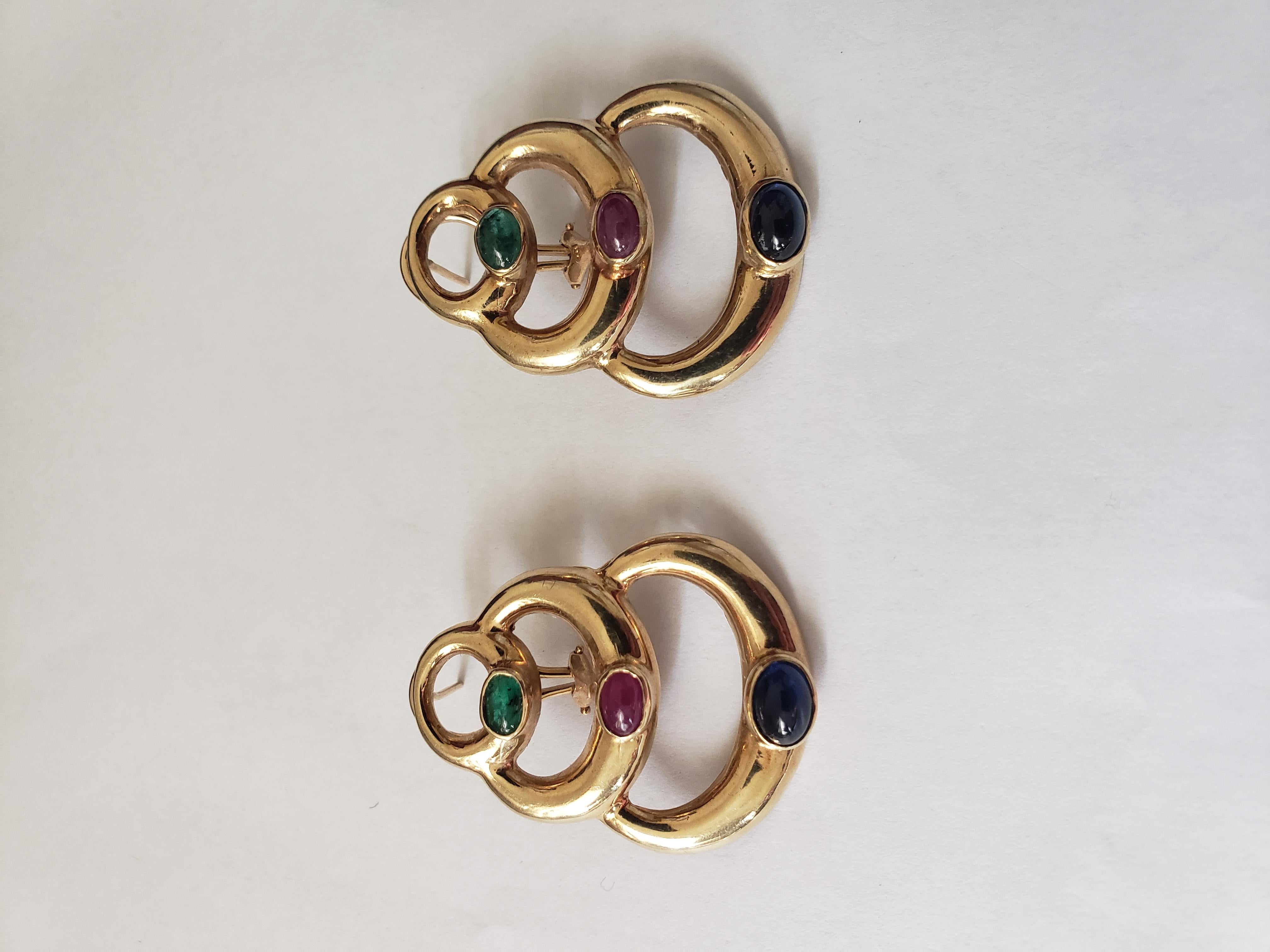 Ces superbes boucles d'oreilles en or jaune massif 14K présentent des saphirs, rubis et émeraudes naturels de forme ovale. Le magnifique thème byzantin ajoute une touche unique à ces boucles d'oreilles faites à la main. Les éléments antiques et