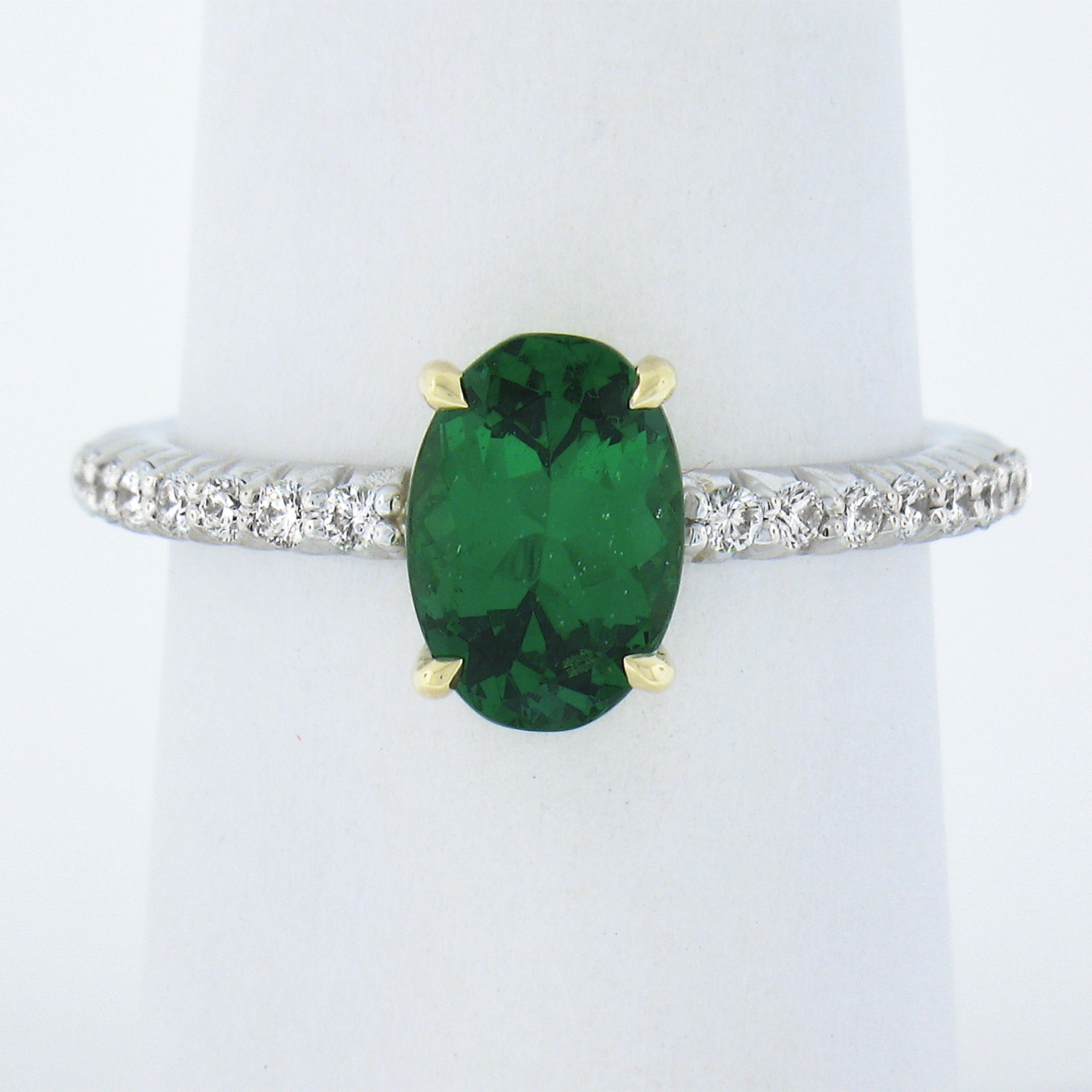 Here we have a beautifully styled tsavorite and diamond ring crafted in solid 14k gold. It is set with a fine quality rich vivid green tsavorite stone neatly claw-prong set in the center yellow gold basket and further adorned on with side of the