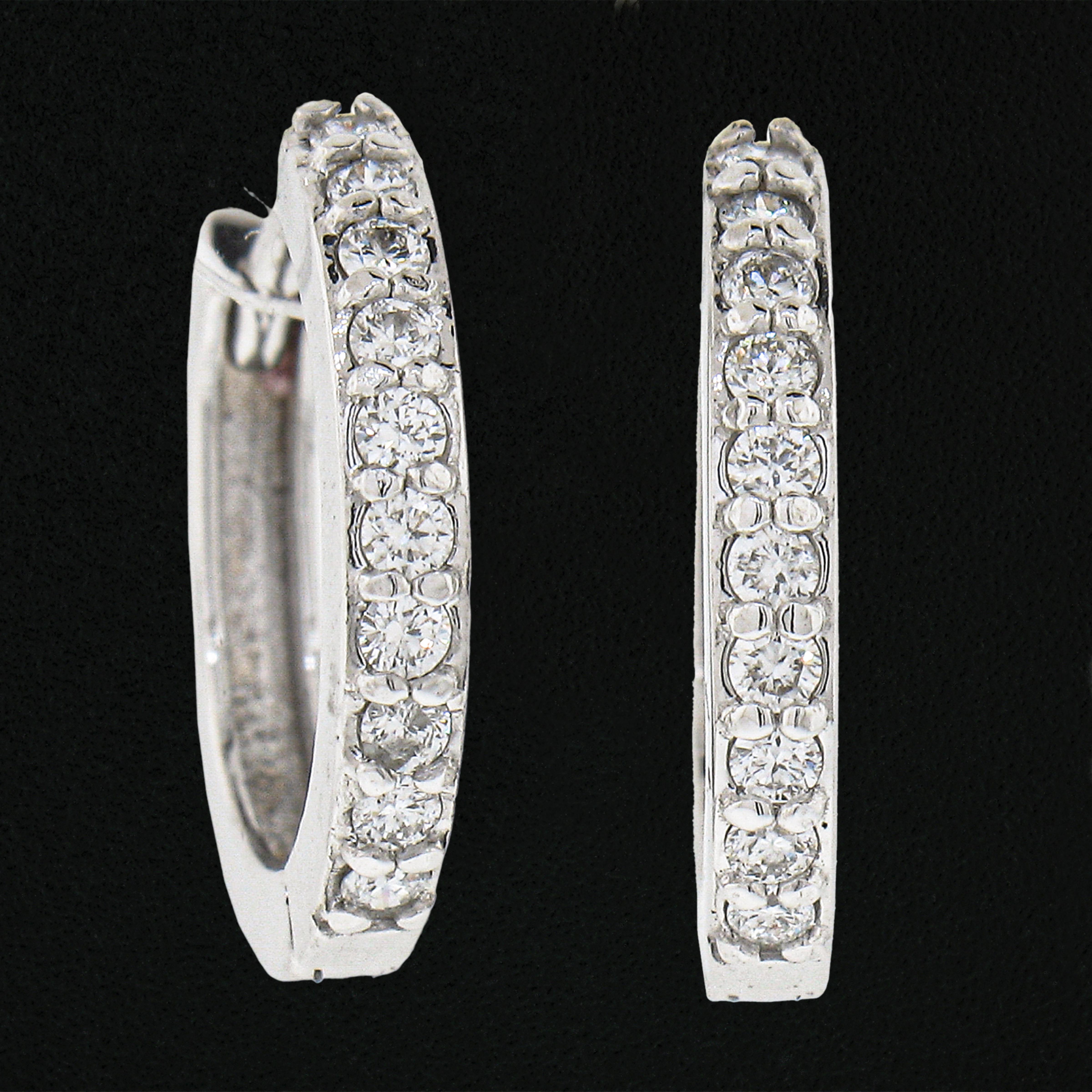This classic and brilliant pair of mini petite hoop earrings was newly crafted from solid 14k white gold and features exactly 0.17 carats of round brilliant cut diamonds. The diamonds sparkle very brilliantly and are shared prong set across the