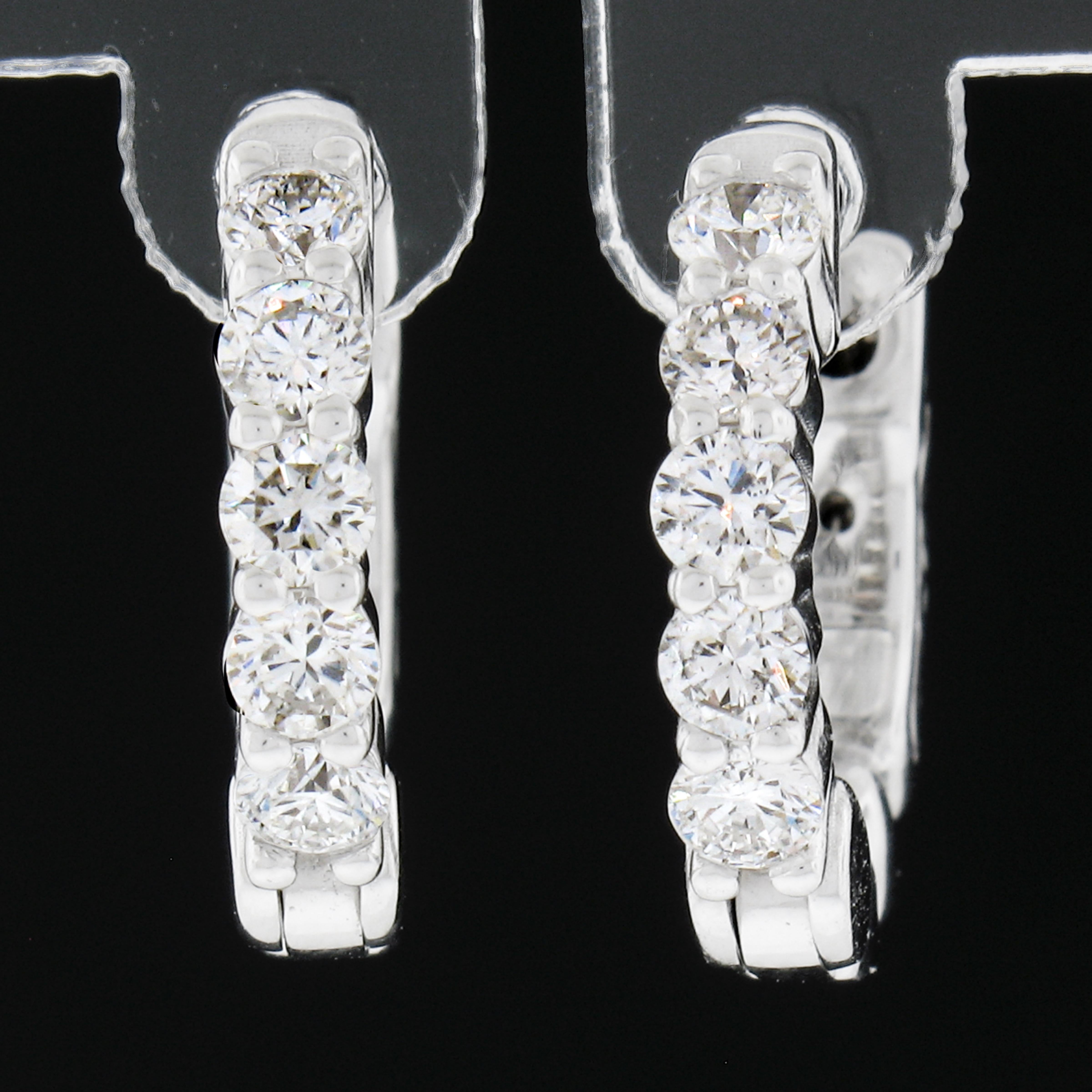 This elegant and brilliant pair of hoop earrings was newly crafted from solid 14k White gold and features exactly 0.51 carats of round brilliant cut diamonds. The diamonds sparkle very brilliantly and are shared-prong set across the front side of