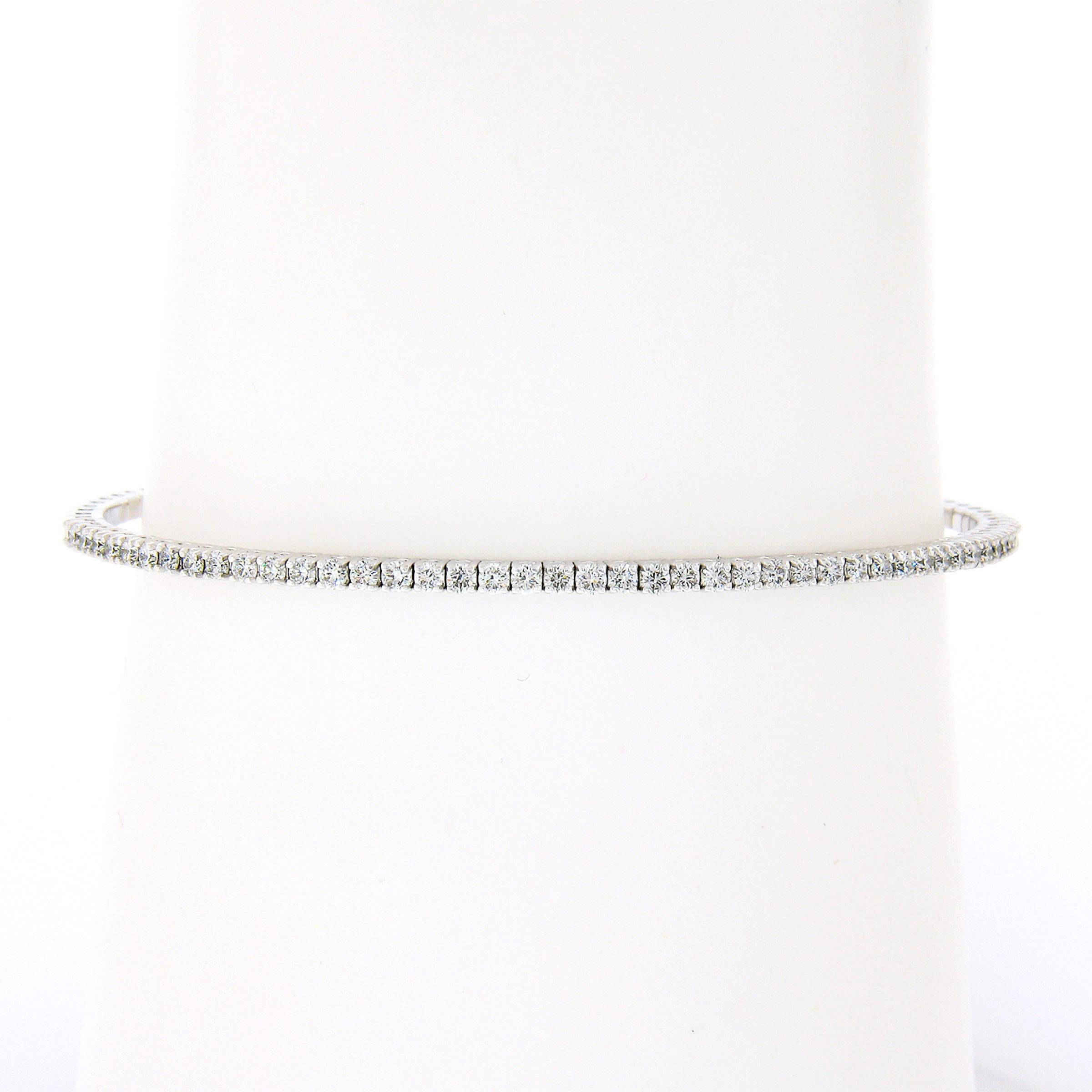 This beautiful, semi-flexible, bangle bracelet was newly crafted in solid 14k white gold and features super quality diamonds neatly set across its top. These fiery diamonds are round brilliant cut and total exactly 0.90 carats, displaying absolutely