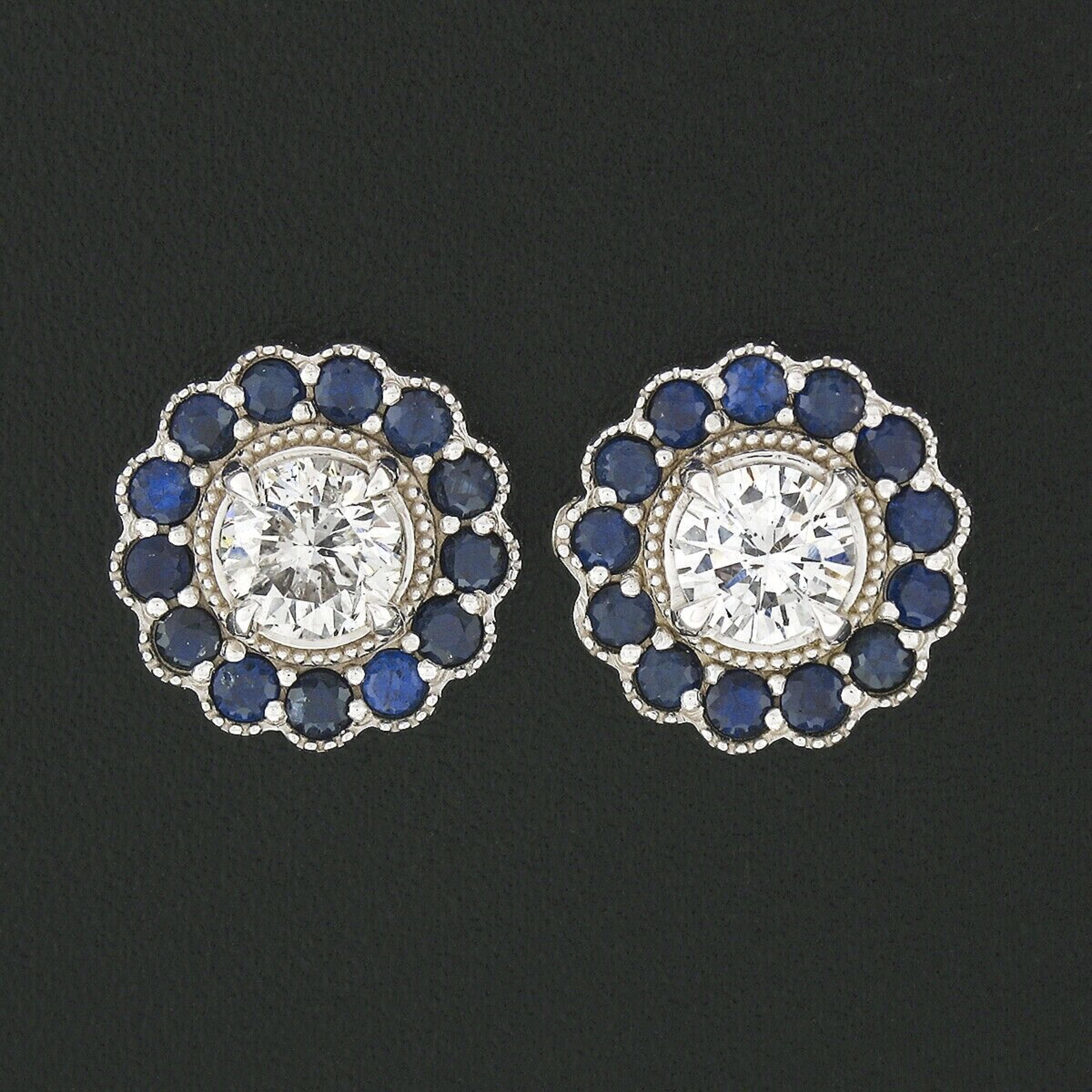 This is an absolutely gorgeous pair of diamond and sapphire cluster flower earrings that very well crafted in solid 14k white gold. Each earring features a round brilliant prong set diamond at its center with a halo of very fine royal blue