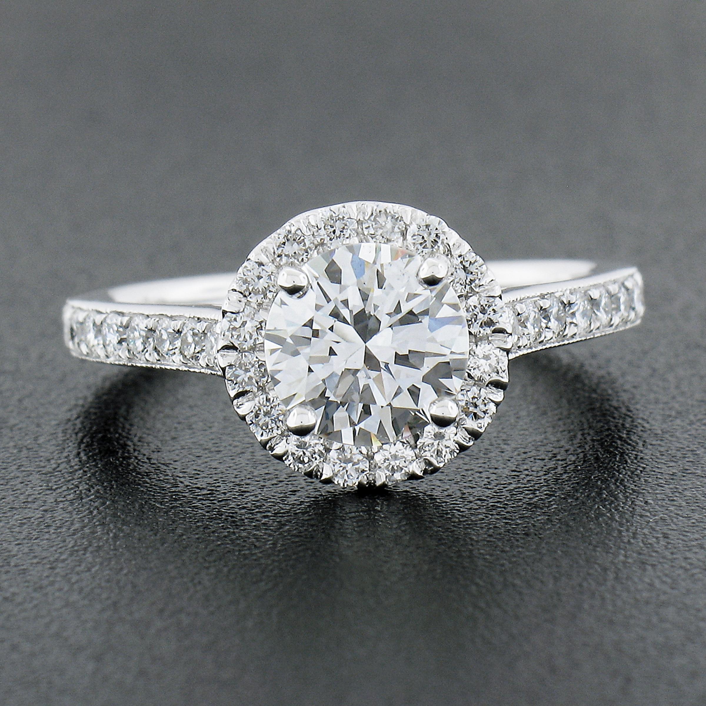 Classic setting with a halo and diamonds down the side that perfectly compliment the high quality center diamond without interrupting the focus on the center diamond! Comes complete with the GIA certification and is ready to make that special