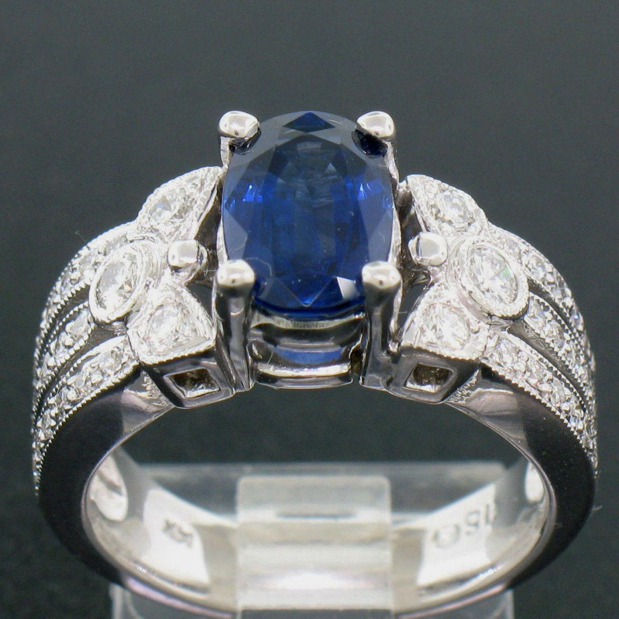 A top quality, 2.18 carat, oval cut, ROYAL BLUE SAPPHIRE sits in a superbly crafted, unique, 4 prong mounting with a wide milgrain design set with SUPER FINE  diamonds running down the sides. A nice, wide, and beautiful mounting! UNIQUE, SUPER FINE