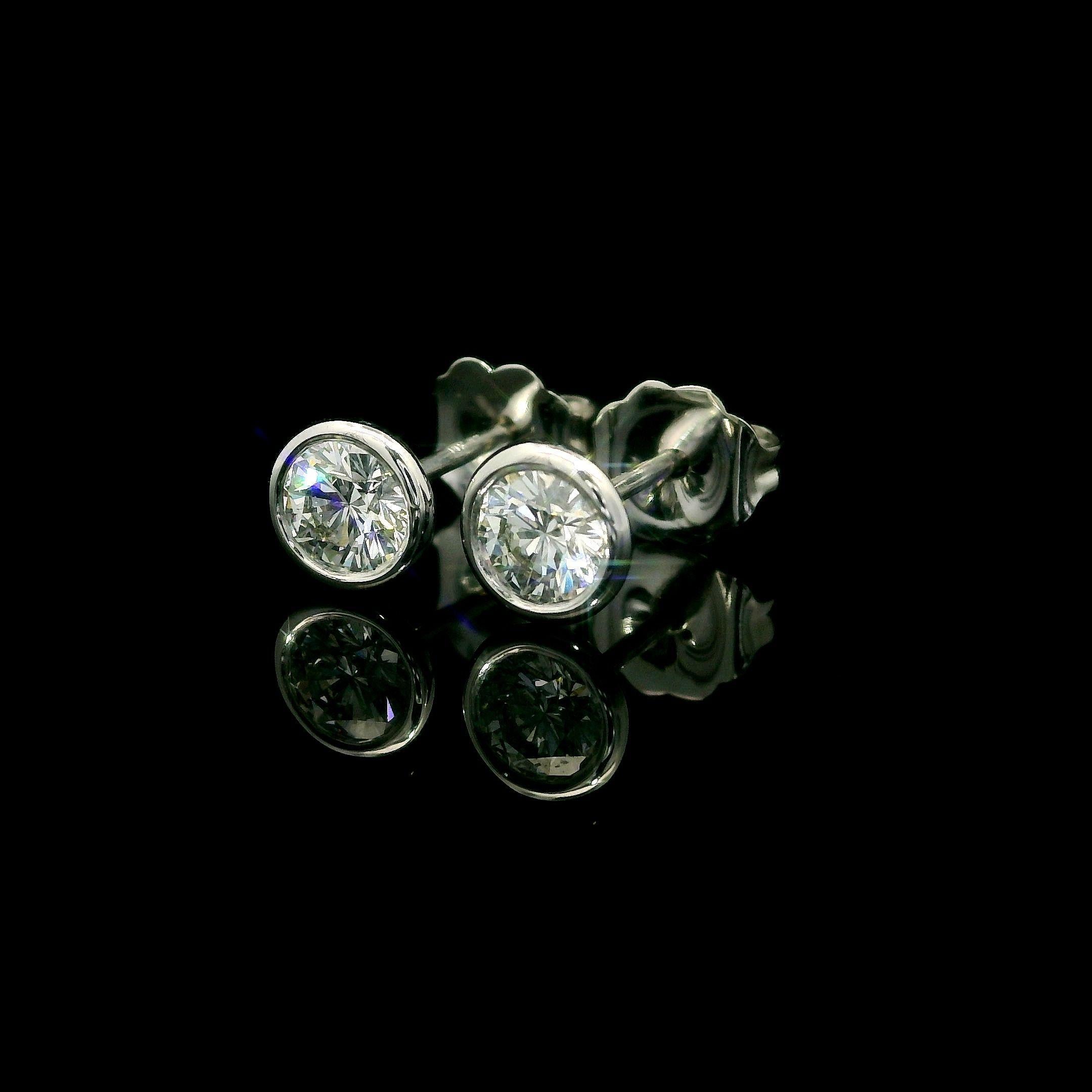 -Stone(s):--
(2) Natural Genuine Diamonds - Round Brilliant Cut - Bezel Set - F/G Color - VS1/VS2 Clarity
Total Carat Weight: 0.53 (exact)

Material: Solid 14k White Gold
Weight: 0.85 Grams
Backing: Post Backings w/ Butterfly Closures (pierced ears